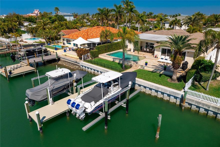 Luxurious coastal living in highly desirable Vina Del Mar Island and just steps to all the fun and activities Pass A Grille has to offer! Grand foyer entry with dramatic ceilings, graciously sized rooms and high-end finishes complement the overall experience this home provides.  This home is often referred as the "House on the Hill" due to the high elevation, it should be coined "Perfection in Paradise" as the home is meticulously maintained!  The fabulous triple split floor plan anchored by gorgeous marble and wood flooring create seamless livability. Whether you enjoy hosting intimate dinner parties or the next family reunion, this home is ready for you! The chefs dream kitchen features custom made Beritch USA cabinetry and kitchen island, quartz countertops and backsplash, state of the art finishes and appliances including built in Sub-Zero refrigerator, dual Wolf ovens and gas stove top with pot filler and Julien porcelain sinks. Master Suite includes volume ceilings, private access to the waterfront, walk in closet with custom shelving organization, separate water closet, walk-in shower and dual vanities. The 2nd bedroom is generously sized with ensuite and walk in closet.  The 3rd bedroom has private access to bath and sliding glass doors to the exterior. Indoor laundry has an additional refrigerator, custom cabinetry with access to the garage.  As fabulous as the inside living affords, the outdoors is truly exceptional along the deep wide waterfront canal.  This is a boaters dream with dockage with a 20K lb and 12K lb boat lifts, refreshing and inviting pool, adjoining hot tub surrounded by an expansive travertine decking with plenty of outdoor patio space and covered dining area.  Are you are a "cook your catch" off of the dock fishing enthusiast or an avid boater seeking easy access and no bridges to the Gulf of Mexico, this home is for you! This is the most unique property to hit the market, it's truly exceptional and is being offered completely furnished! Super easy walk, or take the bike or golf cart to the beach, charming shops and restaurants in Historic Pass A Grille. Easy access to vibrant Downtown St Petersburg to enjoy trendy restaurants, visit acclaimed museums or to catch a Rays or Rowdies game. Quick drive to Tampa Int'l or St Pete/Clearwater Airports, makes business or casual travel a breeze. Click on the Virtual Tour for more photos. Location, Location, Elevation on Vina Del Mar Island!