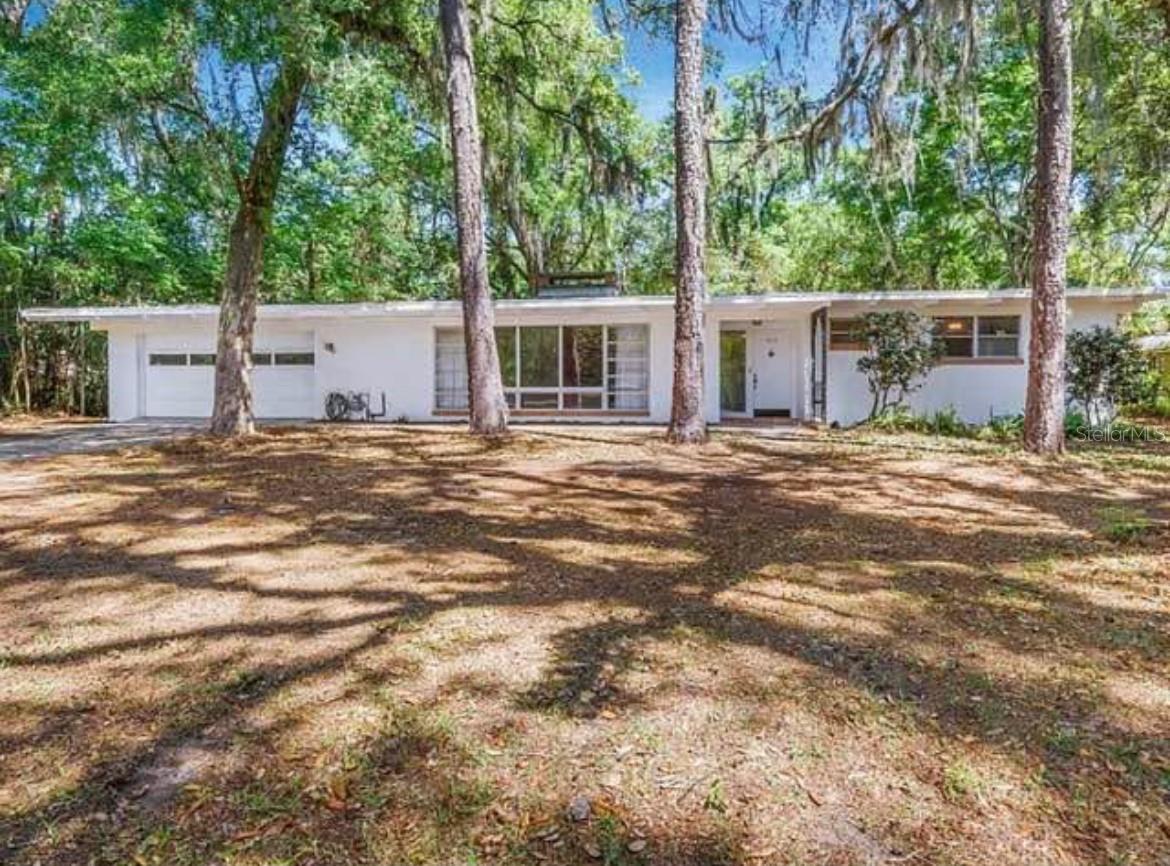 Located 0.9 miles away from UNIVERSITY of FL. Home is PERFECT for UF STUDENTS, ALUMNI & Affiliates who want to stay close to campus…only a 10 minute walk. Highly Coveted Neighborhood. Home has Incredible OPEN FEEL around the Kitchen with three Large Living Areas; LIVING ROOM, DINING AREA & FAMILY ROOM. The Architecture feels Eichler Style with LARGE VAULTED CEILING with Wood Burning FIREPLACE in Living Room. KITCHEN has been Updated with WOOD CABINETS & GRANITE COUNTER TOPS. Home has almost a Half Acre Lot while the Large Backyard Area is Ideal for Outdoor BBQ’s, Activities and Entertaining. NEW ROOF July 2025. Newer A/C 2024. The Huge 2 CAR GARAGE provides Ample Storage & Parking. Featuring an Extra LARGE DOUBLE DRIVEWAY, with Extra Front Drive Access. The Property sits in a Convenient Location with easy access to almost all retail conveniences like Publix, Home Goods, Schools. A 2 minute Walk to a Very Nice Park. Seller may be open to a Lease Option to Buy or Seller Financing. Call to Set Appointment to View.