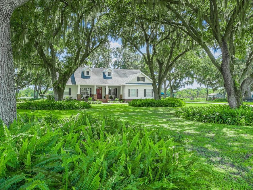 Nestled on a sprawling approximately 14.49-acre plot, this captivating house offers a peaceful and private retreat. The home features four bedrooms and three bathrooms, encompassing approximately 2,901 square feet of thoughtfully designed living space. BRAND NEW ROOF 4/2025. The majestic oaks lining the entrance create a charming and inviting atmosphere. Inside, the home boasts a double foyer that opens to the formal dining room and living room, featuring soaring ceilings, decorative niches, and crown molding. The private office, with its large window, provides an ideal setting for a home workspace. The kitchen showcases Kraftmaid cabinetry, black galaxy granite countertops, and brand-new appliances. The separate dinette area offers a private entry to the lanai through French doors, creating a serene and inviting space. The expansive family room, with its wood-burning fireplace, provides ample room for family gatherings and relaxation. The primary bedroom, a generously sized suite, features a private sitting area and French doors leading to a private entry to the pool area.The primary bathroom boasts a decorative tile shower, luxury vinyl plank floors, a soaking tub, double sinks, double walk-in closets, and a separate water closet. The inviting lanai overlooks the lush pasture, offering a calming environment. The property also boasts an impressive 1,300 feet of creek, teeming with fish, and a 50-by-95-foot, 6-horse stall barn, equipped with automatic water and 100-amp service, allowing for future loft expansion and 12 x 12 tack/tool room. Horse lovers will love while vinyl fenced riding arena with round pen. The property also features an oversized 2.5-car side-entry garage and ample parking on the long concrete driveway.