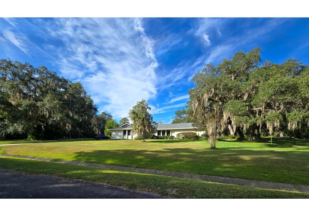 Nestled next to the amazing beauty of Payne’s Prairie lies YOUR new personal retreat.
Imagine coming home to find the sun streaming through the branches of the mature oaks as the Spanish moss gently sways in the cool breeze. On over an acre of green, gently rolling land, there is plenty of space to take a relaxing walk to see what has bloomed today, pick a grapefruit or persimmon, or enjoy the visiting birds and deer.
Or imagine you have guests over for a scrumptious dinner. While cooking in the spacious kitchen with hardwood maple cabinetry and granite countertops, your guests relax at the bar and lounge area, sipping wine and enjoying the warm glow of the fireplace. You set the table with your favorite dishes under the sparkling glass globe chandelier and think “this will be a night to remember.”
As you can see, this home truly has it all. Located close to everything in Gainesville, yet on a large estate lot in a peaceful neighborhood, rarely do homes like this come on the market. The master suite is to die for with a sleeping area large enough for a California king bed and side tables, a spacious seating area, large closet with built-in shelving, and bathroom with spa tub and skylight. And the second bedroom suite has it’s own wing for privacy. Natural light pours into rooms with expansive windows throughout, and the sunsets in fall enjoyed from the comfort of your screened porch are unrivaled. Other features include: two living spaces, ample storage and closets, 3rd bay in garage for golf cart/mower/tools, outdoor firepit, mature landscaping including live oaks, fruit trees, camelias, etc. Make sure to view the seasonal images around the home and yard to experience some of what this home. This one won’t last long!