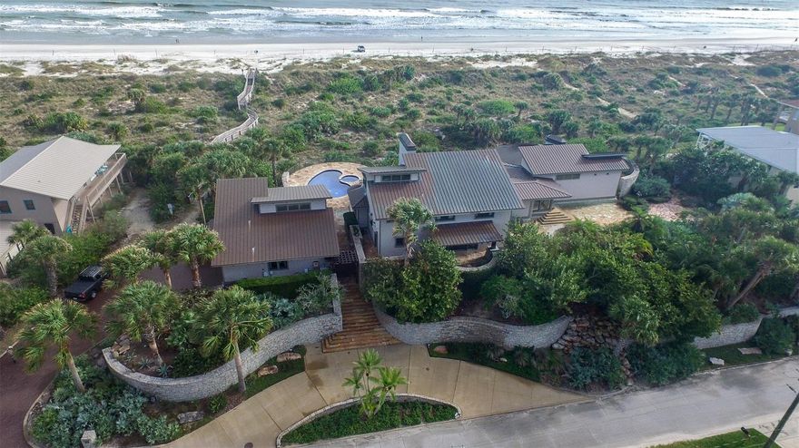 Direct oceanfront North beach stunning craftsman home and guest cottage surrounded by hand-laid stone walls, beautiful terraces and gardens. 180 ft of ocean frontage with over an acre on the ocean. The beautiful main home and guest cottage are connected by gorgeous hand-placed stone terraces. The main home includes 5 bedrooms (master suite downstairs) 4/2 baths, chef's kitchen and butler pantry, dinning room, living room and reading room overlooking expansive patios, pool, spa, dunes and ocean. The first floor has a library-media room, bar enclave and an extensive owners' retreat semi circular in design with panoramic views of the ocean and has a walk through 24x10 closet leading to a tasteful master bath. There are fine interior appointments from the exposed massive oak beams, to the custom cabinetry throughout the main home and guest cottage. There is a 3 car garage with a climate controlled wine cellar. The main circular drive and stairway are hand cut laid stone. Interior wood work was handcrafted onsite from African mahogany, oak, white oak and cherry woods. Stained glass accents and statues compliment many features of this estate. The glass in-laid kidney shaped pool and spa, an outdoor kitchen and several outdoor dining options transition the inside to outside in this one of a kind oceanfront retreat. ;Water: City