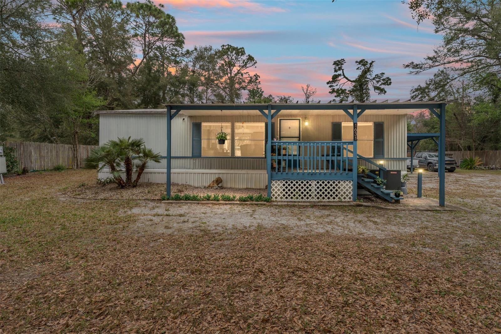 BACK ON THE MARKET DUE TO FINANCING ISSUE. Have you been looking for a home with privacy and space close to THE VILLAGES? Look to further! Welcome to this 2/2 fully renovated home that is TURN KEY and MOVE-IN READY on almost half an acre- fenced! Just minutes from town you will find this serene area free from HOA dues, bonds and deed restrictions. You'll have no worries with NEW plumbing, tie downs, electrical wiring, and appliances! Wait until you see this bright open floor plan with LUXURY VINYL PLANK throughout. The kitchen has been completely updated with new SS APPLIANCES, high def countertops and NEW WINDOWS. The primary bedroom has a large WALK IN CLOSET and EN SUITE with walk-in shower, new vanity/mirror/fixtures and extra storage cabinets. The guest room has a Walk-In Closet as well with access to the 2nd bathroom with tub/shower combo and new vanity. The large front porch is inviting for that morning coffee and the huge fenced backyard (130'x73') is perfect for pets, games and gardening. There is a 2-car covered CARPORT (20X20) and a new WORKSHOP/storage shed (17'x12'). You'll have additional storage in the front shed (10'x13'). There is a new protected water filtration system (well), HWH (2022) and maintained HVAC (2013). The roof has been sealed, painted and maintained and there are no leaks. This home will provide privacy and quiet in a country setting but just minutes from everything wanted- shopping, dining and entertainment. You're a quick commute to nearby towns- Lady Lake, Ocala and Wildwood. This home offers everything including freedom and worry free living. EMBRACE THE TRANQUILITY!
