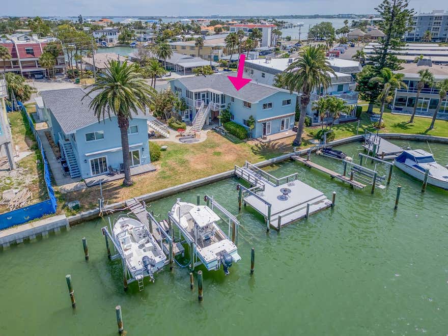 RARE WATERFRONT FIND WITH BOAT SLIP, AND GARAGE Discover the ultimate coastal lifestyle in this exceptional 2-bedroom, 2-bath waterfront condo located in the highly desirable Island Estates community of Clearwater Beach. Now offered with a $10,000 price improvement, this is your opportunity to own a truly rare property featuring a deeded boat slip (fits up to 30' boat), detached one-car garage, private driveway, and bonus storage room-all at a price point that's unmatched on the Island! This turnkey furnished upper-level end unit is move-in ready and ideal for full-time living, a seasonal escape, or an income-generating investment (1031 exchange friendly). Located in a pet-friendly building with 30-day minimum rentals, the flexibility and potential here are unbeatable. Inside, you'll be greeted by an open, sun­drenched layout with bamboo-style plank flooring, plantation shutters, and charming coastal decor throughout. The updated kitchen features white cabinetry, subway tile backsplash, Corian counters, and newer stainless steel appliances-perfectly designed for function and style.  The primary suite offers a tranquil retreat with an updated ensuite bath, while the second bedroom is perfect for guests or your home office. The Florida room is a favorite space for sipping coffee in the morning or enjoying sunset cocktails with water views and dolphin sightings. Additional highlights include: Newer dock just steps from your door New seawall Community laundry facilities or option to install in the condo Exempt from new Florida condo legislation (Senate Bill 4D) Low-maintenance coastal living in a well-managed, 2-story community Walkable to everything on Island Estates-Publix, Island Way Grill, Windward Bar & Grill, nail salons, dry cleaner, UPS, gas station, and more! Hop on the trolley, bike, or stroll to award-winning Clearwater Beach for world-class sand, dining, and entertainment. This is more than a home-it's a lifestyle.