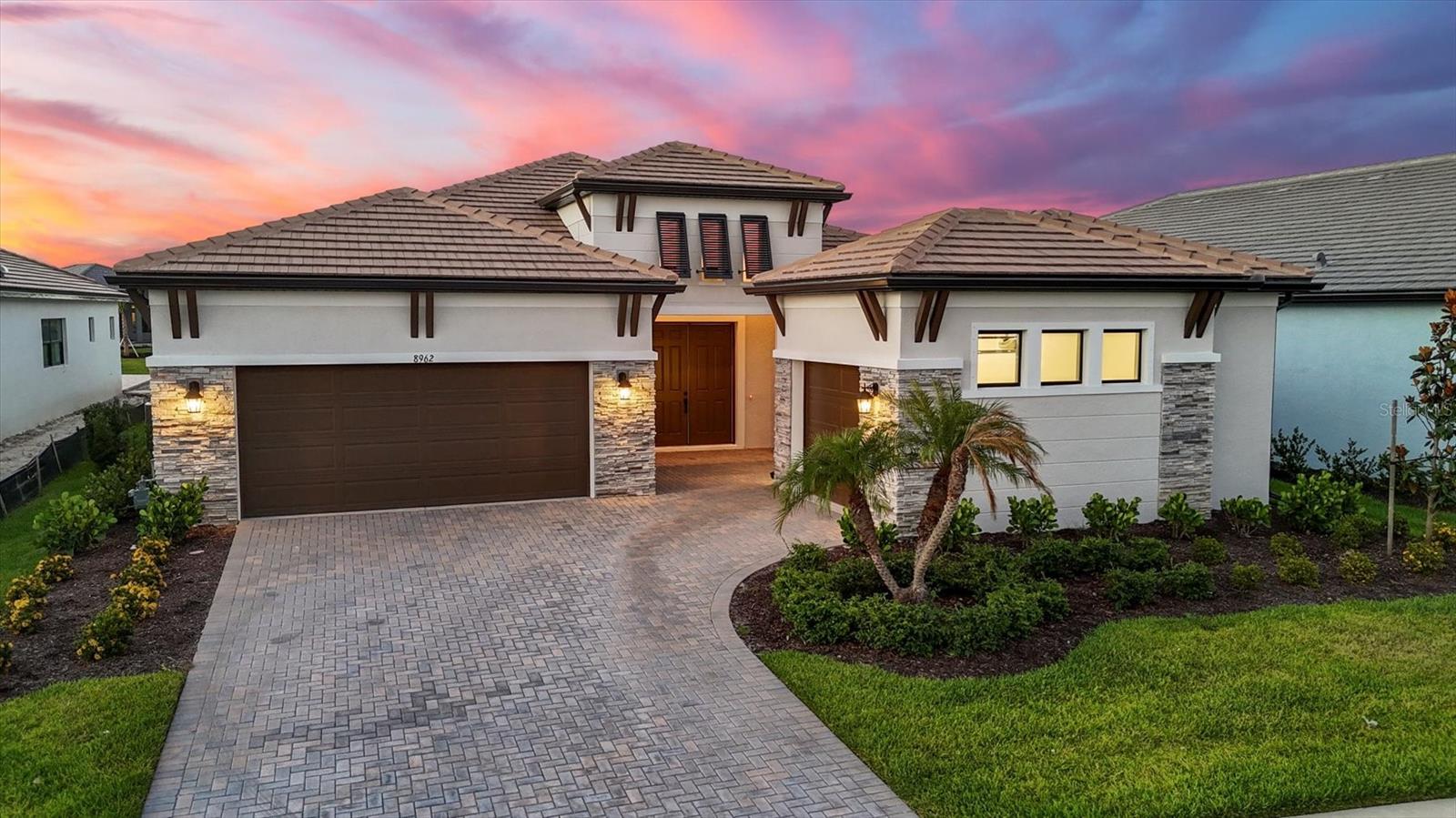 One or more photo(s) has been virtually staged. New construction, without the wait! Recently completed, never lived in and not in a designated flood zone. This beautifully designed Picasso model by Cardel Homes offers generous living spaces with an optimal floor plan. In Artistry Sarasota, you can experience luxurious resort-style amenities, security and maintenance-free living, without the CDD fees! From the moment you and your guests enter this residence, you’re greeted by soaring ceilings, elegant features and thoughtful design. From its grand entrance hallway to its spacious living areas, this three-bedroom, 3.5-bath home (all are en suites) provides large gathering areas and cozy conversation spaces throughout. In addition to the requisite living areas, this home offers two additional large private rooms, both filled with natural light and set apart by French double doors. One of these is perhaps a spacious private office, the other an open yet separate bonus room that could make a wonderful game room or workout area. Conveniently adjacent to the bonus room and across from the lanai door is a half bath. The owners’ suite is quite spacious with tranquil pond views, tray ceiling and dual walk-in closets. Its en-suite bath is designed for relaxation with an oversized walk-in shower, soaking tub, dual vanities and water closet. The well equipped kitchen features a walk-in pantry, upgraded solid wood cabinetry, spacious island, a high-end appliance suite including a natural gas cooktop, range hood, built-in wall oven and microwave, as well as a large buffet with cabinetry and granite countertop. The owners of this fine residence chose ideal upgrades, from the easy-living wood grain plank tile flooring, tile backsplash, wood ceiling beams, shiplap accent wall, custom plantation shutters and a tankless water heater. Even the outdoor lanai area is plumbed and wired for a kitchen. In addition to all the aesthetic features, this upscale residence offers the energy-saving feature of spray foam insulation in the walls and the convenience of garage parking for three cars – one garage for two vehicles, another for one vehicle. Community features and amenities include two gated entrances, huge community pool, clubhouse, tennis and pickleball court, playground area and fitness center, all surrounded by miles of tranquil, landscaped walking paths. Artistry is a maintenance-free, upscale community with no CDD fees, convenient to just about everything that makes Sarasota and Lakewood Ranch desirable, particularly the shopping, dining, entertainment, excellent schools and destination beaches. There is an art to living well and you’ll find it here in Artistry, every day!