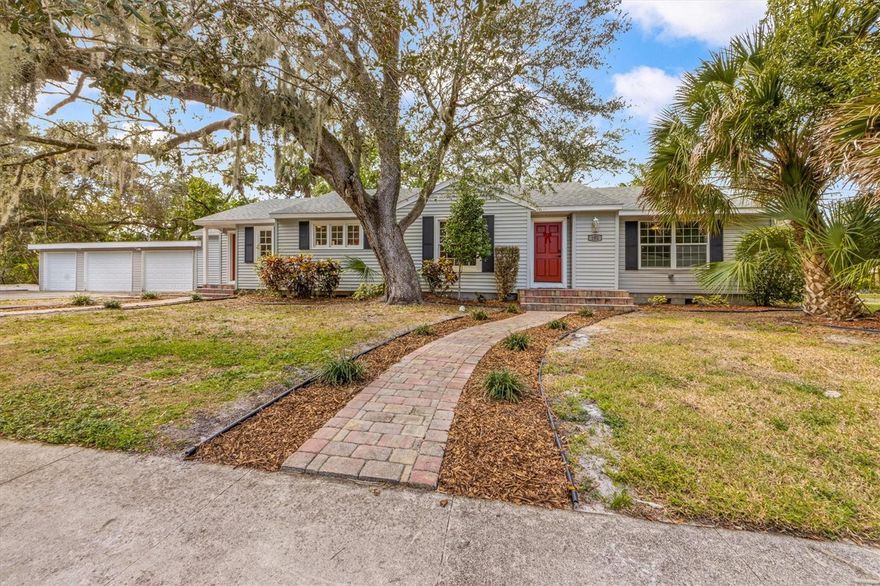 Welcome to your dream home in West Bradenton's highly desirable and coveted Historic River District! This charming 3-bedroom, 2-bathroom + Den Cottage-style ranch offers the perfect blend of historic character and modern convenience.  Nestled in on a secluded oversized corner lot, less than a block from the Manatee River and a 5 minute walk to Lewis Park, you'll immediately appreciate the quiet & quaint streets and beautiful surroundings which highlight true Old Florida charm.   Step inside and be captivated by the architectural details like built-in shelving, a wood-burning fireplace, and crown molding that add an elegant touch, while the open floor plan seamlessly connects the living, dining, and bright kitchen.  The sizable kitchen is a chef's delight, featuring ample counter and cabinet space, granite countertops, stainless steel appliances, and a cozy breakfast nook. The split bedroom layout ensures privacy for everyone. Retreat to the master suite with its high ceilings, large walk-in closet with custom built-ins, and private access to the backyard. The ensuite bathroom boasts dual sinks, a walk-in shower, and a vanity/make-up area. Two additional bedrooms featuring original refinished hardwood floors and a versatile office/den with private access provide plenty of space for your needs.  Outside, the possibilities are endless in the huge, fully fenced backyard. NO deed restrictions is the name of the game and allows you to make all your dreams come true. It is an entertainer's paradise, offering plenty of room for a pool – as well as a perfect private retreat for pets and people alike. Plus, a 3-car garage with additional storage makes this home a rare gem! You'll have plenty of space for all your toys.  Enjoy peace of mind knowing the roof and plumbing were replaced in 2021, brand new AC unit installed 2025 as well as new large capacity washing machine. This prime location puts you just minutes from Downtown Bradenton and the stunning beaches of Anna Maria Island. Don't miss this opportunity – schedule your showing today!
