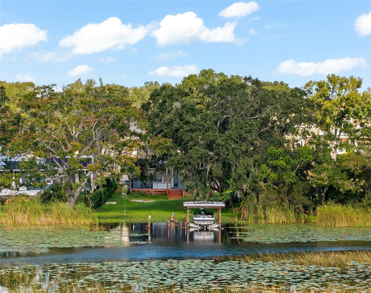 Welcome to your waterfront paradise on the beautiful Windermere Chain of Lakes! This 3 Bed, 2 Bath, 1,351 htd. sqft lake home sits on a 0.29-acre lot overlooking Lake Down, one of 13 lakes on the Butler Chain of Lakes. As you enter the front door you are greeted by an open floorplan, panoramic views, split bedroom layout, renovated kitchen and baths, ceramic wood-look tiling and adorning wood paneled ceilings. The backyard is a water enthusiast's dream thanks to the direct water frontage with an oversized backyard, screen enclosed porch, fire pit patio, and a private boat dock with an electric boat lift. Boasting stunning views and the potential for a variety of water activities, from boating to skiing, this lot presents an exceptional opportunity to create a luxurious lakeside retreat.