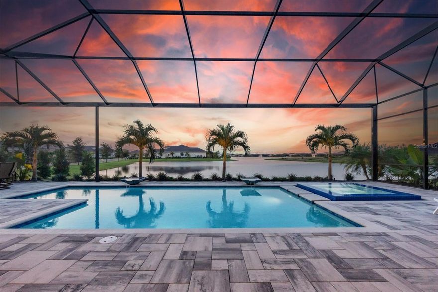 Premier luxury living is now available in the prestigious Lake Club of Lakewood Ranch. Peacefully situated on a stunning lakefront is this 2021 Stock Homes Sterling III true 4 bedroom and 4 bathroom home with large bonus room and study. Adorned with impeccable contemporary styling, even the most discerning buyer will feel right at home. A spacious corner lot with meticulous landscaping sets the stage with amazing curb appeal that will make neighbors and visitor envious. The beaded impact glass double front door entry provides natural light plus a sense of privacy as you enter into the open floor plan with porcelain wood-look plank tile flooring, clean architectural lines, and cove crown molding throughout. The great room is a testament to simplicity and elegance with white beamed ceiling, textured designer wallpaper feature wall, built-in entertainment center, and sliding glass doors to take in the long lake views. Culinary greatness awaits you in the kitchen featuring an expansive central island with wrapping counter-height seating, an abundance of crisp white cabinetry with lighted display shelving, stainless steel appliance suite by KitchenAid, quartz counters, and subway tile backsplash. Preparing meals while preserving a clean and organized kitchen is easily achieved with the spacious walk-in pantry and an adjacent dry bar with wine storage. Whether you are having a casual dinner with family, or a formal dinner party, you have the perfect venues for both in the dinette overlooking the lake or the formal dining room with designer chandelier. Working from home is a joy in the convenient and private study with glass French doors and tray ceiling. This floor plan also features a large bonus room that can be used as a media room, fitness space, play room, or a fifth bedroom, anything your imagination and lifestyle desires. Your master retreat will quickly become your favorite room in the home with a spacious layout, French doors to the lanai that give you a lake view from the moment you wake up, and dual walk-in closets with custom shelving. The master bathroom has been upgraded beyond the builder’s specifications to include a larger walk-in shower, dual split vanities, makeup vanity, and additional storage. Guests will find their own serenity in the 3 guest bedrooms all with walk-in closets, two of which feature en-suite private bathrooms while the final bedroom shares a convenient full pool bathroom. Enjoy the best of the Florida outdoors on an enhanced paver lanai with a large covered entertaining area, plus a built-in outdoor kitchen to rival the indoor kitchen with stainless steel grill, beverage refrigerator and ice maker. Soak up the sun in the heated saltwater pool and spa with water features while overlooking the lake through panoramic screening. Completing this impressive residence is a Sonos system, 3-car side entry garage with custom storage cabinetry and workbench, and efficient laundry room with trendy tile and plentiful storage. The current owners went above and beyond to enhance your future home with custom garage storage, and updated landscaping with lighting. You’ll also enjoy a lower property tax bill than other homes because the debt portion of the CDD Lakewood Ranch Stewardship has been PAID OFF. The Lake Club is a private gated community including a grande clubhouse, restaurant, pool, tennis, pickleball, playground, basketball, Linear Park, fitness center and interlinking lakes for kayaking or fishing.