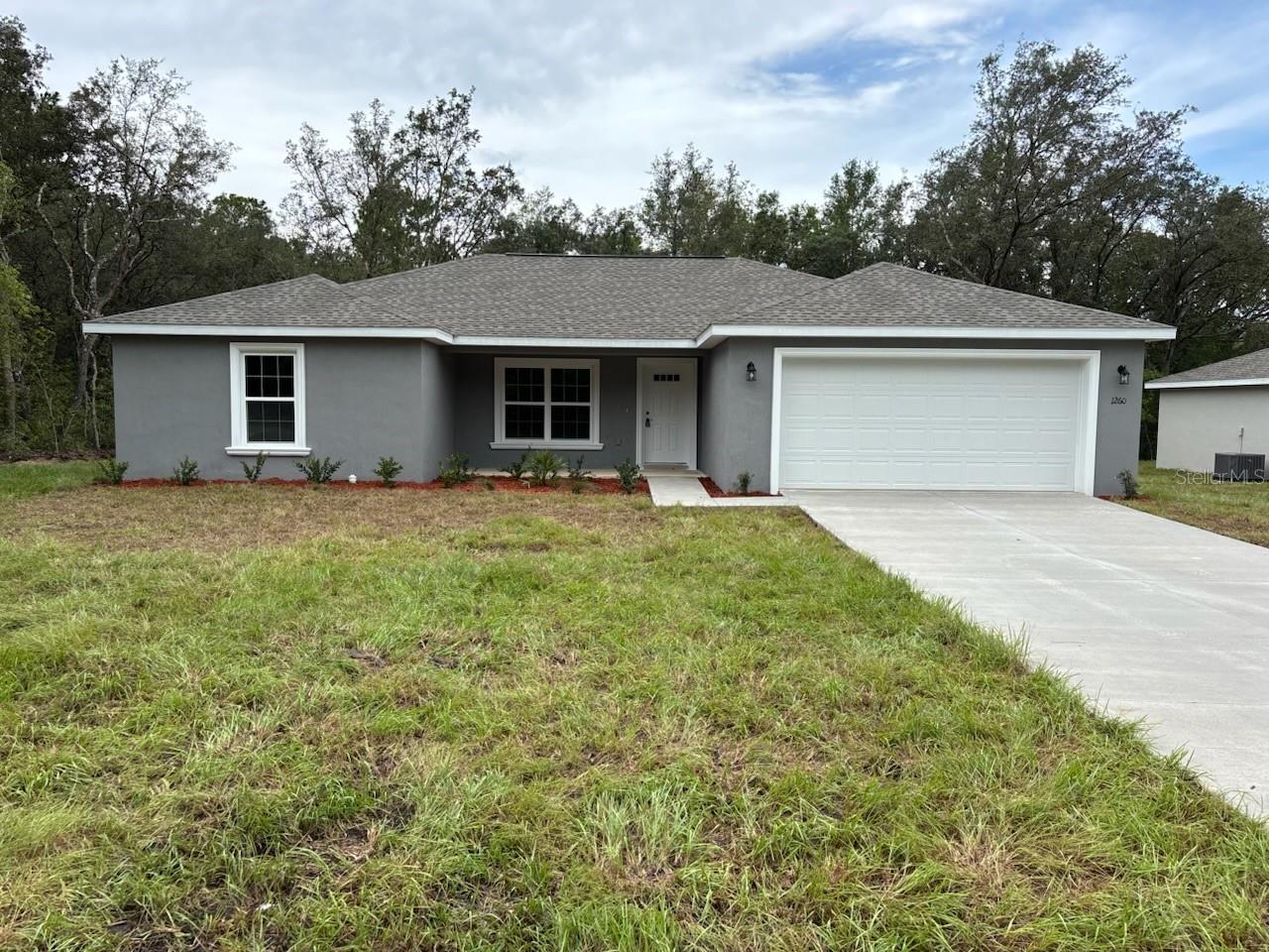 NEW CONSTRUCTION. MOVE-IN READY! This beautiful Marquesas model features 4 bedrooms and 2 bathrooms, spanning 1,646 square feet of thoughtfully designed living space. Located in peaceful Dunnellon, this home features solid concrete block construction, a durable 30-year architectural shingle roof, and energy-efficient double-pane windows. Inside, you'll find an open floor plan with a vaulted ceiling in the living room and luxury vinyl plank flooring throughout. The kitchen includes custom white shaker cabinets with soft-close drawers, a walk-in pantry, granite countertops, stainless steel appliances, and a stylish subway tile backsplash. Both bathrooms feature upgraded marble-look tile, with a glass-enclosed shower in the master bathroom and a tub/shower combination in the main bathroom. The upgraded cabinet package continues into the laundry room, and the kitchen enjoys a spacious wraparound design. Enjoy outdoor living on the covered patio and the convenience of an attached 2-car garage with opener and remotes. Located in Flood Zone X, this high-and-dry property does not require flood insurance and has no HOA fees, offering added freedom. A 10-year structural warranty is included for peace of mind.