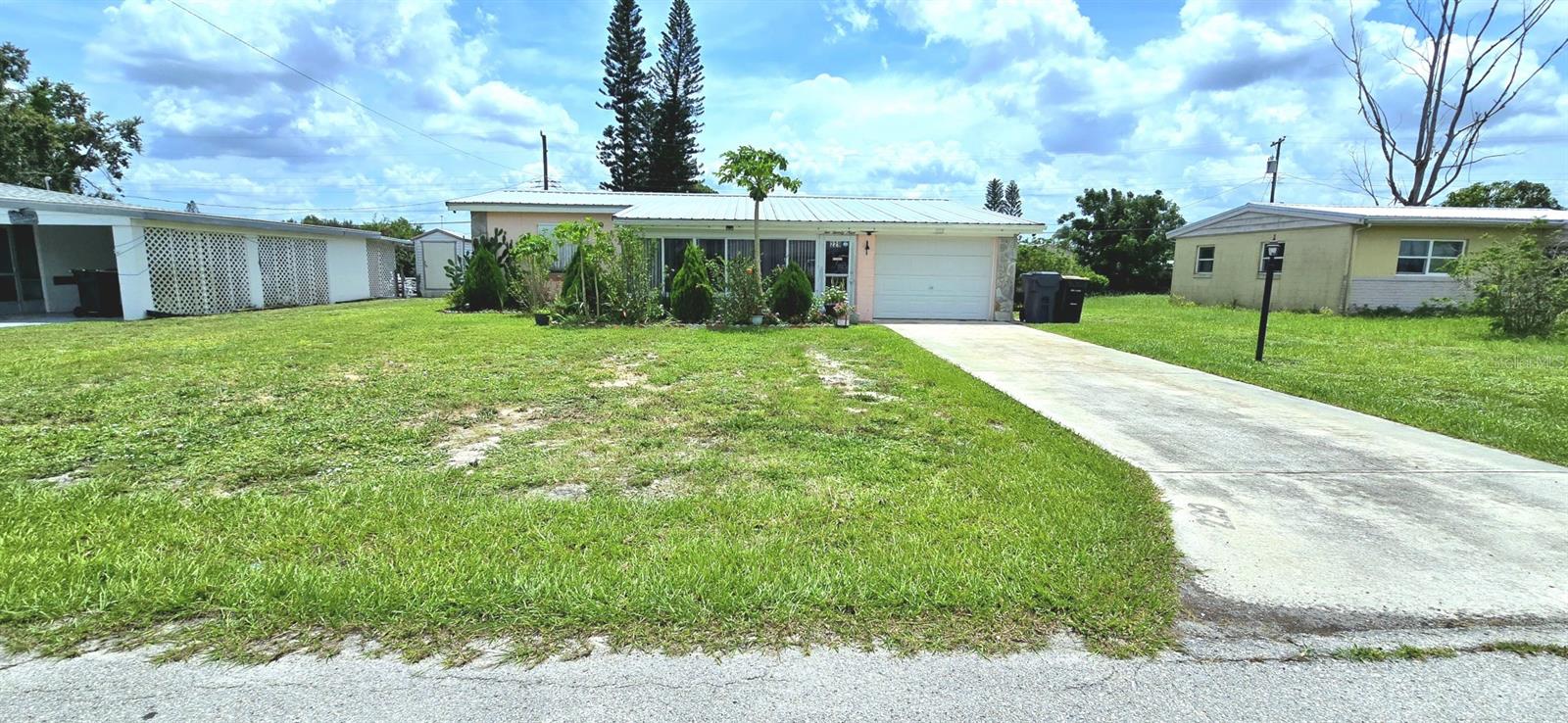 Charming 3 bedrooms, 2 bath home on a spacious fully fenced lot (0.21 acre) filled with lush tropical landscaping and a wide variety of mature fruit trees including mango, guava, lemon, banana, grapes, cherry, and more. Enjoy Florida living with a large gazebo, colorful front flower garden, and a dedicated area for growing vegetables. Inside the home features modern tile flooring, updated kitchen fixtures, new toilets & showers in bathrooms, and ceiling fans throughout. Major updates include newer a/c units (less than 3 yrs old), updated plumbing, newer septic system, and built-in shelving in garage. Bonus features include a separate storage casita and a 24/7 security camera system. Peaceful, private, and move-in ready; this home is a perfect blend of comfort and nature.