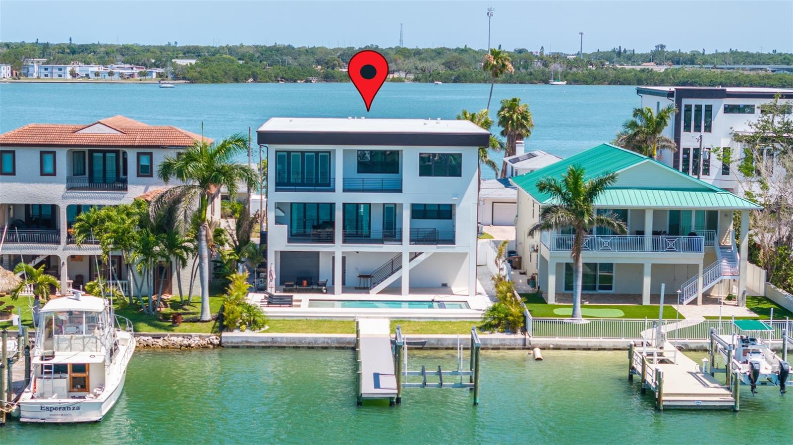 Welcome to waterfront luxury living at its finest in Madeira Beach! Step into this 5-bedroom, 4.5 bath new construction masterpiece designed by Stress Free Construction. This property features: 4427 square feet of living space, a home office, upstairs loft area, ELEVATOR, NEW sea wall, NEW pool & spa, NEW boat dock & lift, and so much more. As you pull into the home, you’re immediately greeted with a paved 6-car driveway and an expansive 3-car garage that accommodates up to 8 cars, complete with a 220V outlet for an EV charger. The entire first floor consists of garage space with ample room for storage & an elevator providing easy access from the ground level to the third floor. The second floor is a chef's dream, featuring a kitchen equipped with stainless steel appliances, a walk-in closet pantry, and an open layout connecting the living and dining areas. A wine cellar, a den, half bath, one of the four bedrooms with an ensuite bath, and an oversized living room complement the luxurious living space. Step out to the second floor covered lanai with an outdoor kitchen with a grill, invites outdoor entertaining with panoramic views. Ascend to the third floor where the opulent master suite awaits, complete with a sitting area, wet bar, massive walk-in closet, double vanity bathroom, and an exterior balcony overlooking the serene waterfront. Bedrooms 3 and 4 each boast their own ensuite bathrooms and walk-in closets, ensuring privacy and comfort for all residents. A spacious game room and a third floor covered balcony further enhance the appeal of this exceptional property. Outside, enjoy the new dock with a boat lift, perfect for launching water adventures, and a new seawall with 110 feet of water-frontage offering breathtaking views of the shimmering water. Located in prime location with easy water access to the Gulf of America, minutes to the most desired beaches, and within 25 minutes to Downtown St. Petersburg. Don't miss this rare opportunity to own a brand new waterfront retreat in Madeira Beach, where every detail has been meticulously crafted for the discerning buyer seeking luxury, comfort, and unparalleled coastal living. Schedule your tour today!