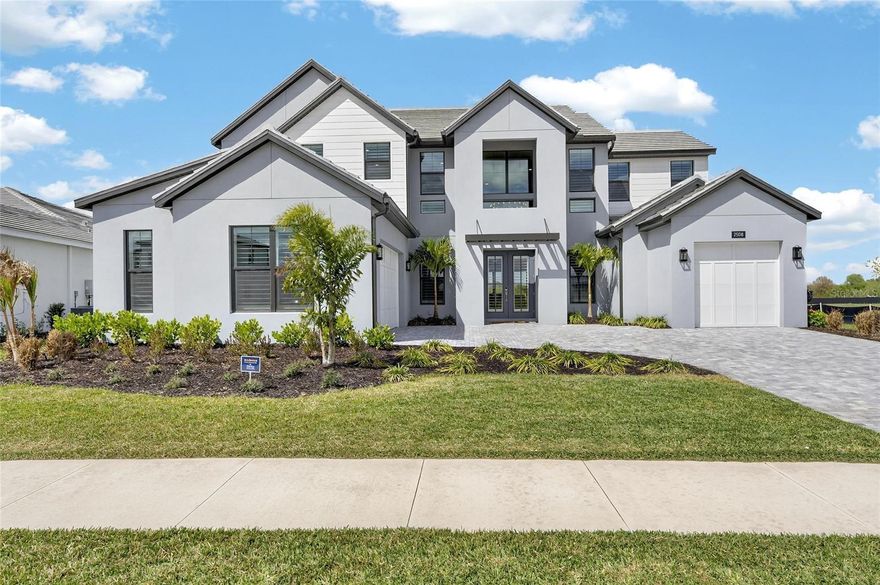 2508 Waterfront Cir, Sarasota, FL 34240 | 5 Bedrooms + Den | 5.5 Bathrooms | 4,695 Sq Ft | Monterey at Lakewood Ranch | Built 2025

Here's something you almost never find: the only resale home in a brand-new neighborhood — and it's better than anything being built around it right now.
While surrounding homes at Monterey at Lakewood Ranch are still under construction, 2508 Waterfront Circle is finished, refined, and ready. But this isn't just move-in ready — it's been taken to another level entirely. The current owners moved in and immediately got to work, hand-selecting and installing high-end fixtures and appointments throughout, and replacing the builder flooring with stunning 9.5-inch wide custom oak hardwood that runs through the main living areas. What you're getting is a 2025-built estate with the kind of elevated interior that most new construction simply doesn't have — and you can see it the moment you walk through the door.
The entry makes an immediate impression. A grand two-story foyer with a custom oak staircase draws your eye upward and sets the tone for the architectural detail found throughout the 4,695 square feet of living space. Ten-inch baseboards, cathedral and tray ceilings, recessed lighting throughout, and a curated custom lighting package complement the home's clean modern lines. Custom Rockwood plantation shutters and a light, neutral palette keep the interior bright and cohesive from room to room.
At the center of the home, the open-concept great room and chef's kitchen form the kind of space that makes you want to host. The kitchen is built for it — an oversized island with pendant lighting and breakfast bar seating, quartz countertops with a full matching backsplash, abundant cabinetry, a natural gas cooktop, built-in oven, stainless steel appliances, a large walk-in pantry, and a separate butler's pantry for the moments when prep space actually matters. The main living areas transition effortlessly to a large second-floor bonus space that works equally well as a media room, game room, or additional lounge area.
The dedicated first-floor office with French doors creates a quiet, private setting for remote work without sacrificing proximity to the rest of the home. Upstairs, the primary suite is a true retreat — tray ceiling, dual walk-in closets, and a spa-caliber bath with split dual vanities, a freestanding soaking tub, and an oversized walk-in shower tiled to the ceiling and fitted with multiple shower heads, a rain showerhead, built-in benches, and inset niches. Three of the four secondary bedrooms feature private en suite baths, every bedroom includes a walk-in closet, and the laundry room is outfitted with built-in cabinetry and a utility sink.
Outside, a large pavered driveway, generous parking, and spacious patio areas carry the same intentionality as the interior — polished, functional, and built to impress before anyone even reaches the front door.
Monterey is a gated community Positioned within Lakewood Ranch — one of the country's premier master-planned communities — this home puts I-75, top-rated dining, golf, parks, and Gulf Coast beaches all within easy reach. Head east on Fruitville Road approximately seven miles from I-75 and you've arrived.
The window to own the only resale in a brand-new neighborhood — already upgraded beyond what the builder left behind — won't stay open long. Call to schedule your private tour.