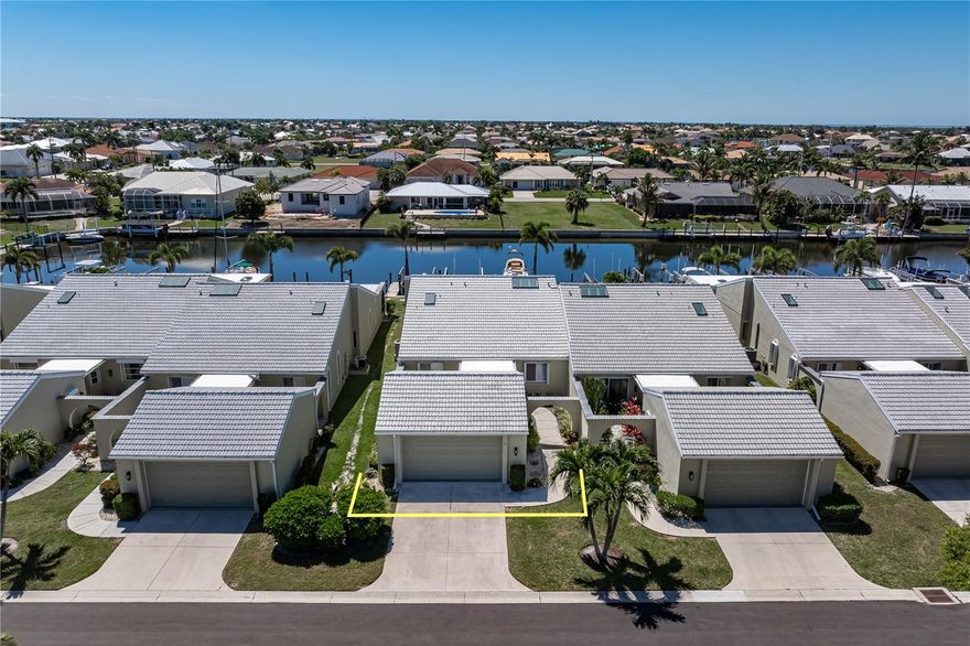 PGI WATERFRONT VILLA W/DEEDED DOCK, SAIL ACCESS & SOUTHERN REAR EXPOSURE! Experience the best of Punta Gorda Isles living in this beautifully updated 3 bed/2.5 bath villa in Isles Cove—where boating convenience, southern exposure, and a move-in ready interior come together in a premier waterfront setting. Ideally situated on an extra-wide canal, the property offers a deeded dock (#13) just steps from the back door and sailboat access to Charlotte Harbor via Ponce Outlet in under 15 minutes. Inside, the home showcases a bright, open layout with soaring cathedral ceilings and skylights that fill the space with natural light. Wood-look tile flooring runs throughout the whole villa, offering both durability and style. The updated kitchen serves as the heart of the home, featuring white shaker cabinetry with soft-close drawers and doors, granite countertops, a subway tile backsplash, and a GE Café stainless steel appliance suite including an induction cooktop and convection oven with air fryer. A large center island with generous seating anchors the space—ideal for casual dining or entertaining. The great room flows seamlessly to the dining area and out to the enclosed lanai, creating an effortless indoor-outdoor connection. The lanai has been upgraded with vinyl sliding panels and a mini-split A/C system, transforming it into a true year-round living space with tranquil canal views and desirable southern exposure. The split-bedroom floor plan offers privacy for owners and guests alike. The master suite features direct lanai access, two walk-in closets, and a spacious en-suite bath designed for comfort. A versatile third bedroom includes a built-in desk and Murphy bed, allowing it to function as both guest space and home office. Step outside to find dock #13 located directly behind the villa. It offers a 16,000 lb boat lift plus water and electric hook-ups. The wide canal provides excellent maneuverability, and the quick access to open water makes this an ideal setup for serious boaters. Additional highlights include a detached two-car garage with private courtyard entry, accordion hurricane shutters, and a NEW tile roof (2024). Isles Cove is a professionally managed community offering amenities like a heated pool, guest parking, and beautifully landscaped grounds. Miles of sidewalks in Punta Gorda Isles connect you to Ponce Park, historic downtown, Gilchrist Park & Fisherman's Village. Life in Punta Gorda is about more than boating—it’s about enjoying every moment. Tee off at local golf courses, rally with friends on the tennis or pickleball courts, or pedal along miles of scenic bike paths. On weekends, the city comes alive with music, art fairs, and vibrant festivals. Add in the weekly farmers markets brimming with local produce and the boutique-lined streets of Marion Avenue, and you’ll see why Punta Gorda is a community where every day feels like vacation. Claim your spot in paradise by making an appointment today.