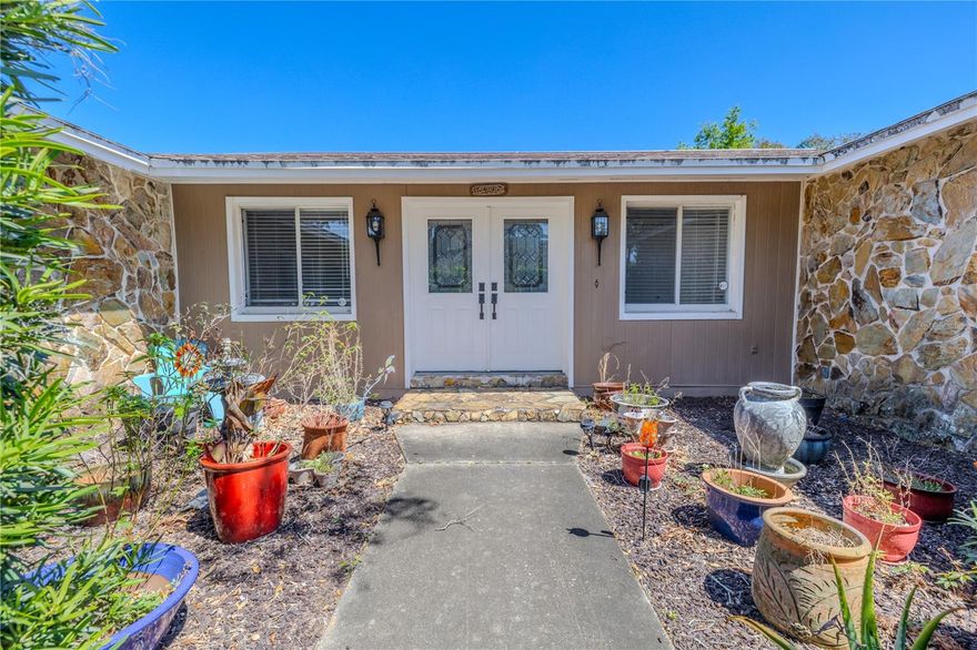 Welcome to your private Florida retreat. Tucked away on 1.27 fenced and shaded acres, this 4-bedroom, 3-bath pool home in Port Richey offers the best of both worlds—room to breathe and live life your way, yet minutes from shopping, dining, and major highways. With no HOA or deed restrictions, you have the freedom to park your RV or boat on-site, bring your toys, and truly make the property your own. From the moment you arrive, the long driveway and detached two-car garage with built-in workbench set the tone for both practicality and possibility. A brand-new roof (August 2025) means peace of mind for years ahead. Inside, the home strikes a perfect balance of warmth and functionality. Double front doors open to a tiled foyer with beveled glass and a wrought-iron accent, welcoming you into the spacious living and dining area. At the heart of the home, the kitchen and family room shine with vaulted ceilings, exposed wood beams, a cozy stone fireplace, and an open flow that makes gathering easy. The kitchen boasts solid wood cabinets with crown molding, granite counters, stainless-steel appliances, and a breakfast bar complete with wine rack. A massive 26-foot-wide bonus room with French doors to the lanai offers endless possibilities—home office, gym, playroom, or game room. Step outside, and the saltwater pool feels like your own private resort, tucked beneath the shade of mature trees and framed by a screened enclosure and covered patio with ceiling fans. The primary suite includes dual walk-in closets, wood-look laminate flooring, and direct lanai access. Its ensuite bath was refreshed in 2025 with new lighting and paint and features a granite-topped double vanity, step-in shower, and plumbing already in place for a future soaking tub. Two additional bedrooms share another refreshed full bath, while the fourth bedroom enjoys its own fully renovated bathroom with a soaking tub and rain shower. A full laundry room with sink and cabinets adds everyday convenience. The backyard is fully fenced and shaded—perfect for pets, gardening, or simply enjoying the peace and quiet. And when you’re ready to explore, you’re just minutes from Werner-Boyce Salt Springs State Park, Jay B. Starkey Wilderness Park, and a short, commutable drive to Tampa via the Veterans Parkway or US 19. This home is more than just a place to live—it’s a lifestyle. With its land, flexibility, and recent upgrades, it’s a rare find in today’s market. If you’ve been searching for space, freedom, and comfort, this is the one.