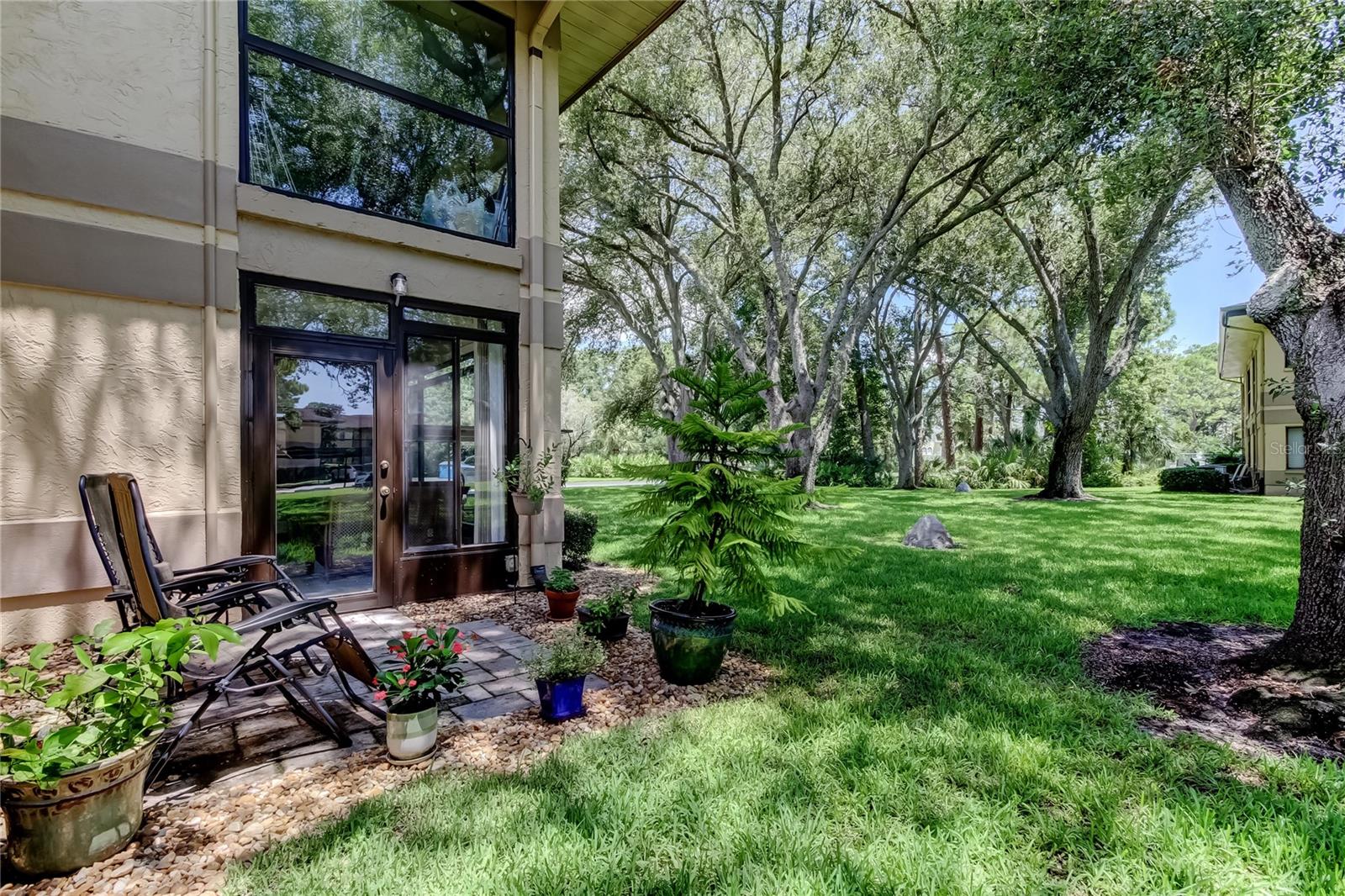 Spacious 3-Bedroom FIRST FLOOR Corner Condo with EV Charging Outlet in a Park-Like Setting! Welcome to this beautifully maintained 3-bedroom, 2-bath first-floor corner unit, ideally located in one of the highest elevations in Clearwater. Tucked into a serene, park-like setting, this condo offers privacy, natural beauty, and modern convenience—just minutes from beaches, shopping, and dining. Step inside to an inviting open layout featuring a cozy fireplace in the living room, and sliding glass doors that open to a bright, enclosed patio—perfect for morning coffee or evening relaxation. Step out to a pavered outdoor patio surrounded by greenery—ideal for enjoying the scenery or soaking in the Florida sunshine. A large storage closet on the patio keeps everything neat and out of sight. The spacious primary suite offers enough room for a sitting area, a private en suite bath, and direct access to the patio. You’ll also love the dedicated indoor laundry room (not just a closet!) with a nearly-new washer and dryer (2024).
Recent major upgrades include a brand-new A/C system (2025) with a 12-year warranty, a new electrical panel (2025), and a whole-house surge protector—all providing comfort and peace of mind for years to come.
This unit also includes a dedicated covered carport with its own EV charging outlet—a rare and valuable feature for eco-conscious drivers. Community perks include a sparkling pool, tennis and pickleball courts, a car wash area, and beautifully maintained grounds that make every walk feel like a nature escape. This well-maintained community has reasonable monthly fees, no pending assessments and no Milestone inspection required (2 story buildings). Whether you're looking for a primary residence, seasonal retreat, or smart investment, this home offers the perfect combination of space, amenities, and location.
Don’t miss your chance to enjoy effortless Florida living at its best—schedule your private showing today!