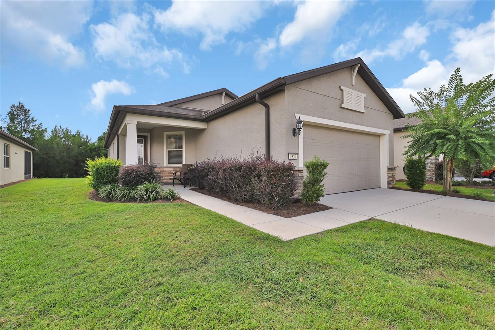 Relax and enjoy a more leisurely lifestyle in the guard-gated DelWebb golf community of Stone Creek with this bright and tasteful Longleaf Garden Home. Lawn maintenance, irrigation, weekly trash/recycling pickup & basic internet are included in the HOA fees. This home features many upgrades including cottage doors, baseboards and trim moldings, 18” ceramic tile floors on the diagonal, a whole-house window blind package & a beveled glass/wrought iron front door w/retractable screen. This very neutral Noir Coast floor plan boasts a bright, large eat-in gourmet kitchen with stainless appliances, ample granite counter space, upgraded wht 45” staggered wood cabinets with dental molding, soft close door hinges and drawers, corner lazy-Susan, pull out cabinet shelves & is conveniently located at front of home for ease of unloading groceries. The handy kitchen pantry and entry drop zone are also easily accessible in rear hallway to garage. The open floor plan provides clear views throughout main living areas, from front door to lanai & beyond. The combination dining and living room areas are situated perfectly for entertaining, w/quick access to kitchen and fully covered screened lanai. The pocketing slider doors from the living room to lanai provide an enlarged opening for ease of entertaining between spaces, and also unobscured views of the lanai & lush backyard privacy berm. The tranquil Primary Bedroom is located away from traffic noise at the rear of home for a good night’s sleep, has an upgraded tray ceiling and will accommodate a king sized bed w/night stands. The bright spa-like ensuite Primary Bath is equipped w/beautiful wood vanity, dual sinks, granite countertop & pocket door from bedroom for enhanced privacy/noise control. The transom window over the large easy-to-clean shower area provides additional light while still providing privacy. The ample Primary walk-in closet contains a built-in dresser and numerous built-in shelves to allow for various storage configurations. A much sought after Guest Bedroom with a nice sized reach-in closet is tucked away in its own wing for maximum guest privacy and comfort. The well appointed and easily accessed Guest Bathroom is just steps away with a single vanity, quartz countertop, tub/shower combo with an easy-to-clean surround, plus a linen closet conveniently located in the adjoining hallway. The spacious laundry room provides room for laundry baskets/hampers, cleaning supplies, pet beds/supplies, other storage needs, or even a small home office. The 2 car garage includes insulated garage door, a wall tool storage rail & upgraded hybrid water heater. Enjoy the DelWebb 55+ lifestyle of the Stone Creek community with many amazing amenities including a membership-optional semi-private golf course, Full Service Health and Fitness/Spa Center, Heated Resort Outdoor Pool and Heated Indoor 25 meter Lap Pool, 5 Tennis Courts, 16 lit Pickleball Courts, 8 Bocce Ball Lanes, Basketball Court, Horseshoe Pits, Community Garden, Dog Park with agility course, Softball Field, numerous Fishing Ponds and miles of walking, biking, golf cart trails and optional RV storage. Socially active, with a dedicated Lifestyle Director and Spa Director and 60+ clubs and interest groups to join, Stone Creek is located within proximity to golf, shopping, dining, medical services, the World Equestrian Center, local attractions and numerous outdoor activities. *All room dimensions are approximate; Buyer/Buyer’s Rep to verify*