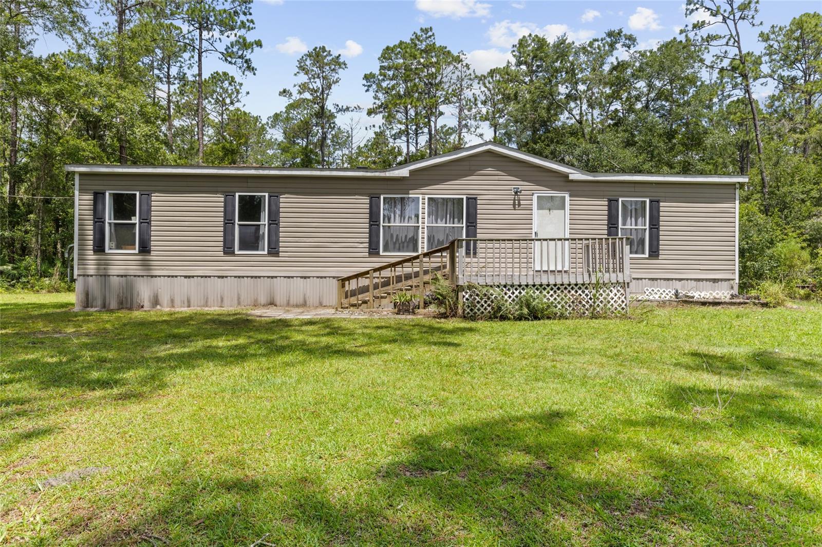 Discover the perfect blend of country living and city convenience with this meticulously maintained 2017 mobile home on 2.5 beautiful acres just outside Gainesville. This move-in-ready property offers 3 bedrooms and 2 bathrooms, providing a comfortable and functional layout for families or those seeking extra space. A large carport accommodates two vehicles, and there’s also a garage for one vehicle or additional storage. Enjoy the peace and privacy of a rural setting while staying just minutes from all that Gainesville has to offer, including shopping, dining, and major employers. With its spacious land, well-kept interior, and ideal location, this home is a true gem. Schedule your private showing today and experience the best of both worlds!
