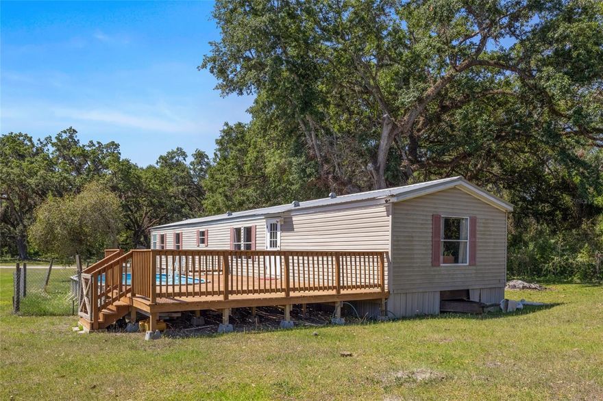 Welcome to this stunning piece of paradise just off Highway 50 in the growing city of Webster! With NO HOA and NO restrictions, this expansive 14 acre parcel offers the freedom and flexibility to bring your vision to life. The lush, FULLY FENCED property features a secure electric gate entrance and includes a VERSATILE WORKSHOP or 3-STALL BARN complete with ELECTRICITY and durable concrete flooring. The completely remodeled 2-bedroom, 2-bath manufactured home with a 2012 metal roof, has a COMFORTABLE and SPACIOUS open floorplan. It features brand new LUXURY VYNIL flooring throughout the home, new luxury bathroom with GRANITE COUNTER, dual sink and a BATH TUB. A new WOODEN DECK with a SPARKING POOL and a CHARMING WOODEN BRIDGE have been added to the property creating the perfect environment to enjoy nature and the RURAL Florida lifestyle. Relax on the deck by the pool enjoying the exuberant nature around or even fish in the pond. All impact fees have been paid, and the property is equipped with ELECTRIC, SEPTIC, and 3 WELLS —the primary well includes a WATER SOFTENER and CHLORINE INJECTOR for added convenience. Zoned as agricultural but with the possibility of being incorporated to the city of Webster and split in smaller residential lots. Mobile homes and single-family homes are both permitted, making it ideal for a variety of residential setups. This property used to be a mobile home park many years ago and there are numerous power points throughout the property. Enjoy proximity to local schools and attractions like the renowned Webster Flea Market, with Downtown Tampa and Downtown Orlando just an hour away. Outdoor enthusiasts will love the nearby Withlacoochee State Forest, perfect for camping, fishing, and hunting. Bring your animals, start a farm, generate income, build your rural dream home —the possibilities are truly endless on this beautiful property!