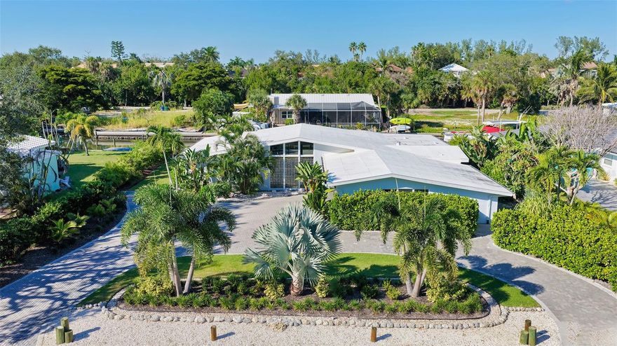 One or more photo(s) has been virtually staged. Welcome to an exceptional mid-century modern waterfront residence in Buttonwood Harbor, custom renovated from the ground up to deliver luxury coastal living. Situated on a deepwater canal with direct Gulf access, this 3-bedroom, 2-bath home offers timeless mid-century architecture, exceptional boating access, and thoughtfully integrated modern upgrades. Boaters will appreciate the private dock with a 13,000-pound boat lift, electricity, water, dock lighting, a raised seawall cap, and effortless navigation to open water. Inside, the open-concept layout centers on a spectacular chef’s kitchen featuring custom shaker cabinetry, high-end appliances, a commercial-grade induction range with vent hood, wall oven, and an oversized quartzite island that anchors the space with elegance and functionality. Porcelain tile flows throughout the home, complementing the fresh interior and exterior finishes. The primary suite offers a spa-quality experience with a freestanding soaking tub, frameless glass walk-in shower, and dual vanities. Additional highlights include a new roof and HVAC system including new ductwork installed in 2020, a large laundry and utility room, a two-car garage, and a circular paver driveway. The outdoor living area is equally compelling, with tropical landscaping, a pergola, firepit, outdoor shower, and room to entertain. Located in one of Longboat Key’s most desirable neighborhoods, the property offers access to a private boat ramp, fishing piers, beach access, and irrigation water through an optional $600 per year HOA. This is a rare opportunity to own a fully renovated waterfront home that delivers both immediate comfort and enduring value. Private showings available by appointment.