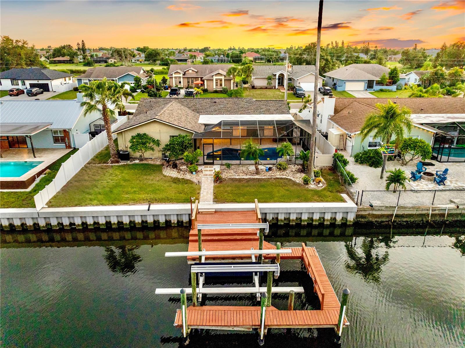 Endless potential awaits in your next chapter of LUXURIOUS WATERFRONT LIVING in coveted Apollo Beach, where sunsets, boating, and sophistication meet. Situated on one of the WIDEST AND DEEPEST CANALS IN THE AREA, this residence is truly a BOATER'S DREAM, offering the largest dock on the canal and a 13,000 lb boat lift with a rare walk-around plank. With no bridges to navigate, large sailboats and powerboats have direct access to Tampa Bay in just 7 minutes. This 4-bedroom, 2-bath, 1,930 sq. ft. home is DESIGNED FOR BOTH RELAXATION AND ENTERTAINING. The split floor plan offers flexibility, allowing you to REMODEL IT INTO AN OPEN CONCEPT LIVING and kitchen area. The spacious interior features hardwood floors, pocket windows, and glass sliders that create seamless indoor-outdoor living while capturing waterfront views throughout. A bright kitchen showcases newer premium KitchenAid stainless steel appliances and PLANTATION SHUTTERS enhance the home with timeless style. Step outside to the OVERSIZED SCREENED LANAI and enjoy the recently RESURFACED PEBBLETEC POOL with LED lighting, automatic vacuum, and new shell and coral rock pavers on the pool deck. The circular driveway, mature landscaping, and EXPANSIVE OUTDOOR SPACE set the stage for endless gatherings or quiet evenings enjoying Apollo Beach's famous BOAT PARADES right from your backyard. ** RECENT EXTENSIVE UPDATES ADD TREMENDOUS VALUE ** and peace of mind, including a brand-new $55,000 CMI vinyl SEAWALL with a 50-year warranty (2025), new ROOF (2025), resurfaced pool (2025), updated HVAC system with UV light (2023), $12,000 plantation shutters with lifetime warranty (2023), interior paint (2023), water heater (2022), and pool pump (2022). With NO CDD OR HOA, this waterfront lifestyle comes without restrictions. Perfectly located close to I-75, Tampa Airport, dining, shopping, and marinas, THIS HOME OFFERS THE IDEAL BLEND OF CONVENIENCE AND COASTAL LIVING. Live your dreams on the water - start enjoying the lifestyle you've always imagined. This dream can be yours.