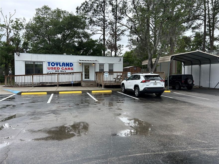 Prime commercial opportunity in a high-visibility Gainesville location. Situated on just over half an acre, this property is zoned business automotive and ideal for an auto dealership or other automotive-related business. The site features over 30 parking spaces, two convenient entrances for easy traffic flow, and a metal side carport perfect for vehicle detailing, covered workspace, storage, or service operations. Ample room for inventory display, customer parking, and vehicle maneuverability. Excellent road frontage and easy access provide strong exposure and convenience for customers. Rare opportunity to secure a spacious lot with flexible commercial potential in a growing area of Gainesville.