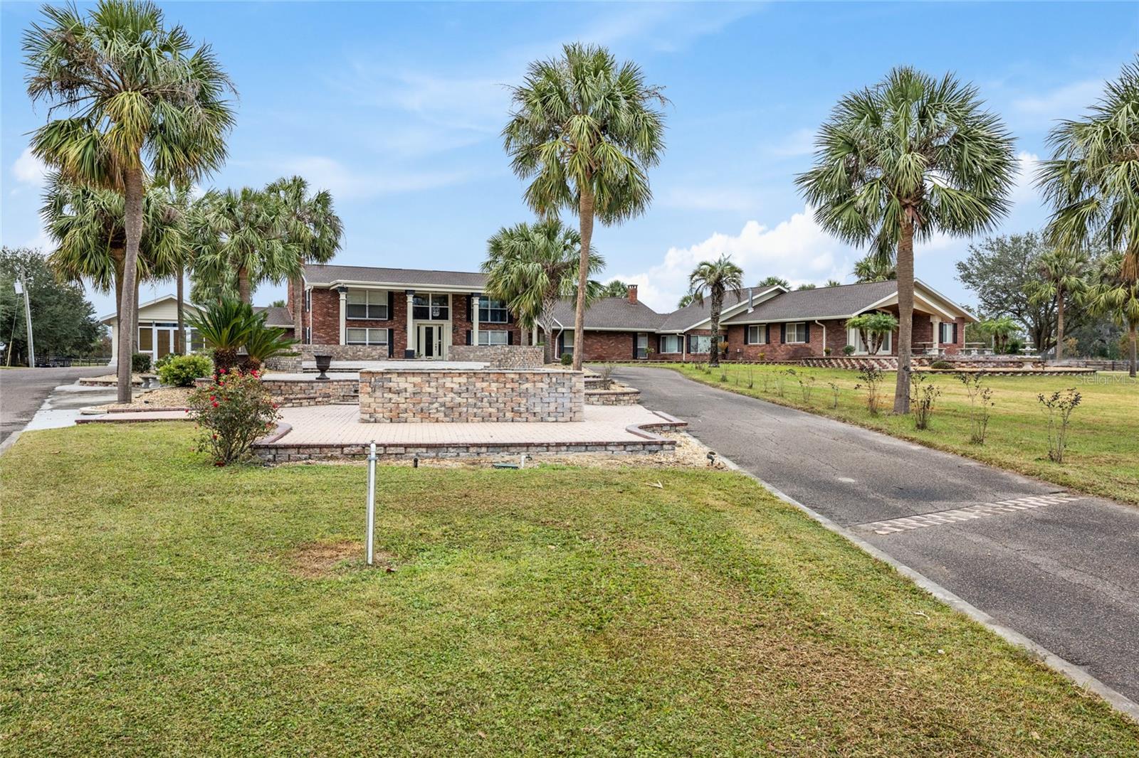 Breathtaking 192 acre Equestrian Estate and Event Center! This massive 13,500 square foot estate home is perfectly set up for either private use or as a large event facility and Inn. The exterior boasts acres of 4 board fencing that was replaced in 2017, 8 septics with lift station, 5 WELLS replaced in 2022, one of which is EPA monitored, three 500 gallon diesel fueling tanks, 2 hay barns with NEW METAL ROOFS and a 10 space RV PARK. The 7 AC UNITS were all added and replaced in 2018 and the NEW ROOF was installed in 2022. The larger center aisle barn is 23 stalls, tack room and wash areas with a 3 bedroom 2 bath apartment. The smaller barn is 16 stalls with tack room and a 1 bedroom apartment. Both barn apartments have full kitchens. There is 90 acres of coastal hay that is currently being harvested and sold. The property has also been approved for 10 additional units on the property. The main home is nothing short of spectacular! There was a nearly 6000 square foot addition added in 2018. The 12 bedrooms all have en suite baths with additional 1.5 bathrooms. The home is currently being used as an event center with a welcome center in the foyer. The entire home is beautifully adorned with imported Mexican Tile. Each bedroom is themed with different states and countries and are perfect for large parties. Three of the 3rd level rooms all have balconies and access to the 100 foot long balcony with extraordinary views! The BRIDAL SUITE is magnificent with its own private deck, small kitchen, jacuzzi tub and large walk in closets. The Dining Hall has a 100 person capacity and there is a commercial kitchen with a 1500 gallon grease trap and separate commercial kitchen storage areas which are equipped to handle large scale events. Just off of the dining hall is the outdoor Tiki Bar with beer draft, full bar and large seating capacity at the bar. There is ample amounts of covered lanai seating and a massive outdoor entertainment area that is large enough for very large events. Also, there are 2 covered 8 person Hot Tub pavilions. The propane generator is large enough to run the entire main home. Just off the outdoor area is a newly constructed event partially enclosed event center that hosts concerts, weddings and large corporate events. There is also a gift shop and an ice cream shop! The main gated entry to the property is completely lined with mature, canopied oaks for a magnificent drive down the 1/4 paved driveway. The possibilities with this property are too many to mention. All furnishings and farm equipment are included with full price offer.