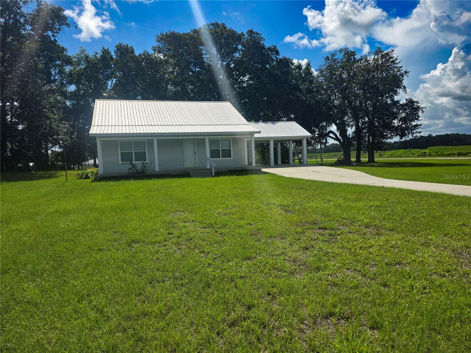 Welcome to this adorable 2-bedroom, 2-bath cottage nestled on a peaceful 1-acre lot in a charming small neighborhood. The home features a lovely porch that stretches across the entire front, perfect for enjoying the fresh air and those stunning sunsets overlooking peaceful farmland. You'll also find a cozy back porch for even more outdoor relaxation.
Inside, you'll find a versatile bonus room that offers endless possibilities — whether you need a home office, craft room, or extra guest space, it’s ready to suit your needs. The bonus room also has its own separate entrance, making it private and convenient.
The kitchen is a dream with a huge pantry that offers plenty of storage, and the large utility and laundry room inside adds to the convenience of daily living. The guest bedroom has direct access to a full bathroom, making it ideal for visitors.
With no carpet throughout, this home is easy to maintain and feels fresh. A spacious double carport provides ample parking, and the location is ideal—just 6 miles to Chiefland and around 30 miles to Gainesville. Come see this perfect blend of comfort, charm, and country living!