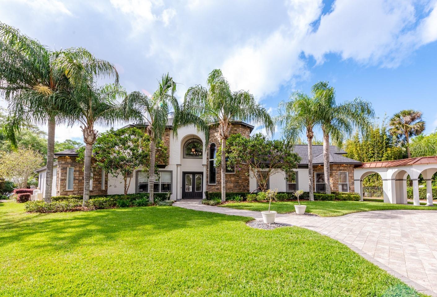 Rare opportunity for Lakefront living on Bear Gully Lake in the heart of Oviedo! This 1 ½ acre gated estate delivers a stunning main home complete with gorgeous water and sunset views, screened pool and a full guest house with an extended garage for a total of seven stalls between both homes! Always wanted a personal basketball court? This amazing property has that too! Traveling through the gate transports you into your own world where adventure awaits, delivering every luxury you can imagine while still feeling the comfort of home! Before you tour the interiors, take some time to explore the grounds that include a circular paver driveway, covered breezeway that connects the homes with an arching entrance to access the garages in the rear! The lush green space is expansive and provides views of Bear Gully Lake as well as a backdrop for your dock and boat house and the perfect place to sit around the fire pit and watch the sun go down! NOT TO BE MISSED HIGHLIGHTS OF THE MAIN HOME; a light and bright open concept with soaring ceilings, top of the line finishes, lake views, a gourmet kitchen with everything a home chef could ask for, dedicated office space, loft with pool table, a main floor Owner’s Suite with beautiful wood floors, updated bathroom (must see shower!), dual walk in closets, view of the pool and lake with a separate A/C for your personalized comfort! There is also a wine cellar off the foyer, crown molding throughout and of course your private screened and heated pool with a Pebbletec finish. When you are not relaxing poolside, this property makes it easy to enjoy the lake life with a private boat ramp to take your boat in and out of the lake, dock with power lifts for your boat and jet skis and a bonus - the property is irrigated with water from the lake! HIGHLIGHTS OF THE GUEST HOUSE; 2000 square feet of absolute charm that include 2 bedrooms and 2.5 baths (each bedroom is an en-suite), large open living area, breakfast nook, private lanais, vaulted ceilings, a two car garage in the front and and extended two car garage in the rear that can accommodate 10’ and a full ski boat! The electricity is metered separately and the attic has a radiant barrier to keep energy costs low! Also noteworthy; there are two whole home Kohler generators and the roof of both homes are new (2022)! In sought after Oviedo, ZONED FOR TOP-RATED SCHOOLS SEMINOLE COUNTY SCHOOLS, with easy access to parks, shopping, dining and major roadways! We have full confidence you won’t want to leave once you step foot inside the gate - this property has the WOW FACTOR you have been searching for and everything you could want in a forever home. THE LAKE LIFE IS WAITING! Call today and schedule your private showing of Tuskawilla Road!