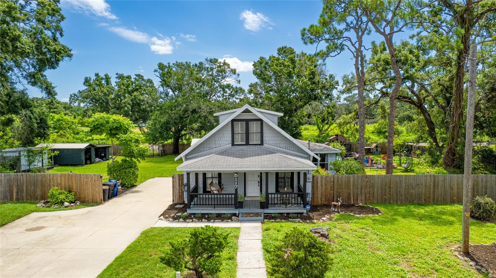 This eclectic home built in 1925 is very charming and unique. It is situated on three lots, comprised of almost half an acre. The location is centrally positioned to enjoy the beaches of Anna Maria Island and Bradenton Beach, the convenience of access to I-75, and the casual urban environment of downtown Bradenton with many shops, restaurants, night life and the weekend Farmers Market. The owner has completed many renovations including a bathroom, new stairway, kitchen, fresh paint and above ground pool that is situated at the end of the deck that was enlarged. This fully fenced property is very large and there are many opportunities and ways to expand if you desire. A traditional front porch is large and greets your guests and friends. As soon as you walk in the charm of this home is very evident. The kitchen is perfectly positioned to connect with the formal dining room and living room. The sunroom offers a great space with many possible uses including a possibility to add another bedroom or office to be open or closed off. The 3rd bedroom was converted into a dining room and can be converted back by adding a closet. A large rear porch is perfect for enjoying the outdoors where covered areas and many trees offer shade. You can enjoy the Florida weather year round with the large deck area and a huge yard with additional accessory structures, some that have water and electric, that are great for storage or your hobbies and there’s plenty of room for extra vehicles from boats to RVs. This property has not sustained any damage or flooding at all. Easy drive to the Sarasota-Bradenton International Airport, many shops, restaurants and endless opportunities in the area to enjoy the multitude of activity that Florida is known for. This IS a must see property. The playground and riding track in the backyard can convey with the property.