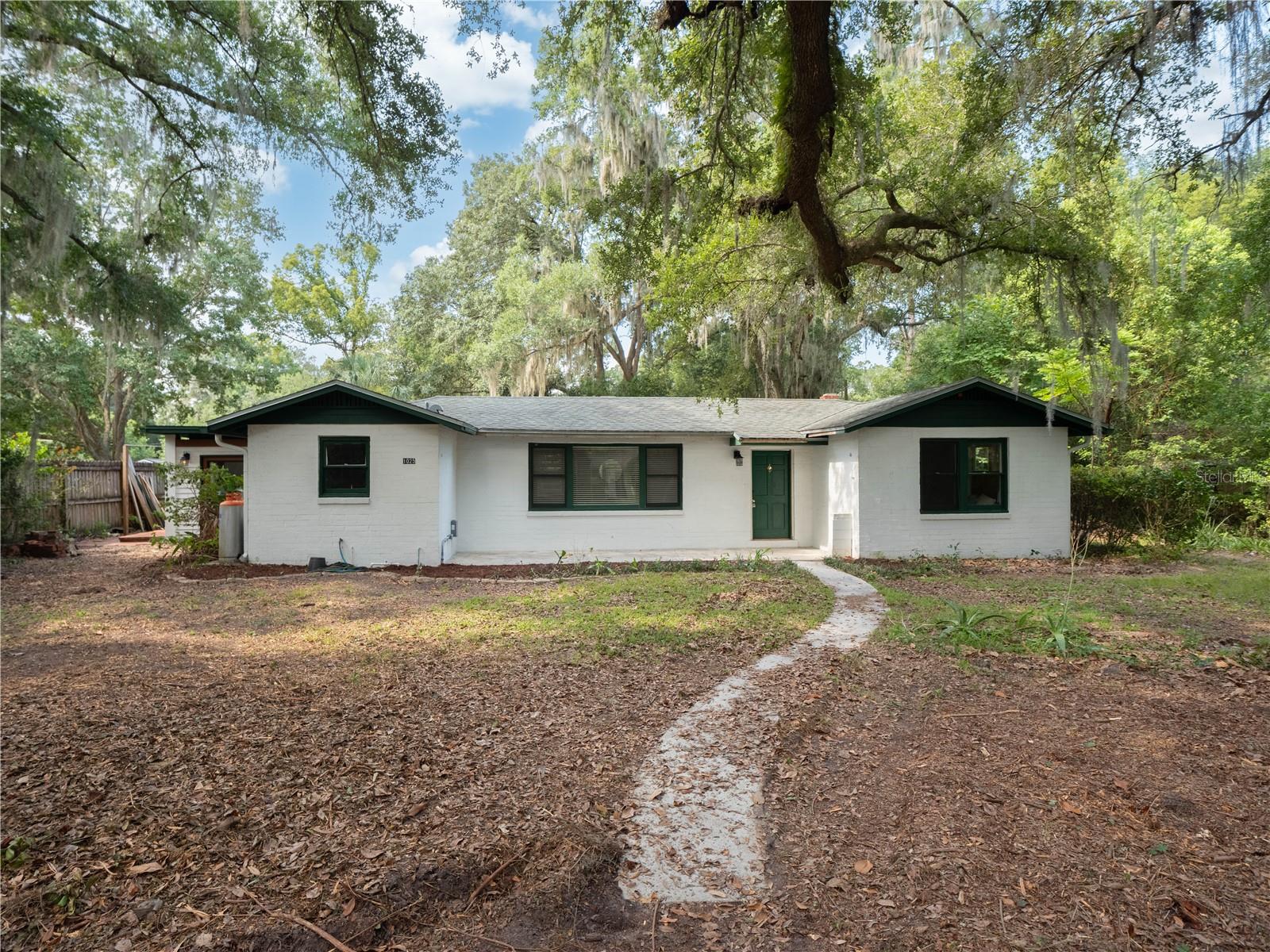 Under contract-accepting backup offers. Situated on one of the nicest streets in the Oakview neighborhood you'll absolutely love this adorable block home overflowing with charm and potential! With cute, well maintained houses in every direction and beautiful oak trees, you'll love driving home everyday. The large front yard has a quaint circle drive and the front porch is ready for a rocking chairs and cafe lighting! As you enter the home, you're greeted by a large living space with a wood burning fireplace and an abundance of natural lighting. To the right of the home, you'll appreciate two large bedrooms with gorgeous antique glass windows and the perfect pink bathroom in mint condition. On the opposite side of the home, is a large galley kitchen with hardwood cabinets and brass chevron handles and space for a breakfast nook. Just off the kitchen is a spacious primary suite complete with a full bath, an oversized bedroom, and an addition ideal for an at home office or study. This charming home and neighborhood is perfect for people seeking convenience to all that Downtown Gainesville has to offer! Call today to schedule your showing. **Buyer to verify all property details.**