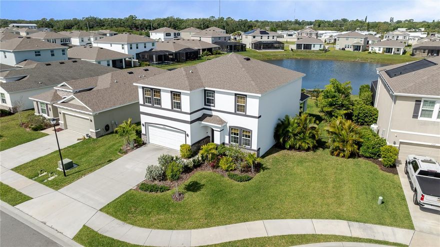 This is not the home you step inside and forget. From the moment you arrive, the lush tropical landscaping, manicured yard, and pond-view lot set this property apart — over $15,000 in professional landscaping and a fully fenced backyard give it a privacy and warmth that new construction rarely has. Built in 2021 and thoughtfully customized throughout, this 5-bedroom, 3-bathroom two-story home sits on a quiet dead-end cul-de-sac and offers 2,738 square feet of living space in a great location — minutes from shopping, dining, and just 25 minutes to the Gulf Coast beaches. The open-concept main floor features custom built-in cabinetry in the living area, a spacious kitchen with dark espresso cabinets, granite countertops, subway tile backsplash, a light filled dining room and large island with seating. A dedicated home office with French doors sits just off the main living area. All carpet has been replaced with luxury vinyl plank flooring and the staircase has been fully updated with wood treads and risers. Upstairs, the primary suite features custom picture frame molding. Additional bedrooms each carry their own personality and designer touches. A 5th bedroom with closet, added from the original loft space, adds real flexibility and lasting value over a standard floor plan. Bathrooms have been updated throughout. Outside, enjoy direct pond views, a fully fenced backyard, and sweeping water views as the neighborhood backs up to the Braden River. Tucked inside a gated community, enjoy access to a beautiful pool and pergola gathering area.