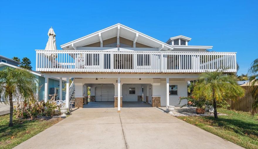 Welcome to this elevated coastal retreat in the heart of Redington Shores.This light-filled home offers three bedrooms and two bathrooms, complemented by a versatile space that could be used as a guest suite, home office, or gym. Designed with both comfort and functionality in mind, the main living level features vaulted ceilings and an abundance of windows that create an open, airy ambiance throughout.  At the center of the home, the kitchen is surrounded by two distinct living areas, each open to the outdoors. Kitchen features custom cabinetry, farmhouse sink, stainless steel appliances, breakfast bar, all set within a neutral palette ready for your personal touch.  Step outside to the oversized balcony and take in peaceful water views and Gulf breezes from your own private vantage point. The elevated design enhances your water views and offers peace of mind, all while maintaining a sensible and spacious floor plan. Added features include 1 car garage, 2 car carport, storage room and a large driveway. The private backyard is perfect for enjoying the outdoors with your furry friends. Located within walking distance to the beautiful beaches of Redington Shores, this home invites you to embrace the laid-back coastal lifestyle. Whether you're searching for a primary residence or a beachside getaway, this home is ready for its next chapter—bring your vision and make it your own.