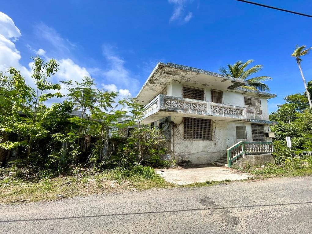 This idilic property has 6.5 acres of land that extends south from the quiet, up and coming neighborhood of El Pilón. Among its many interesting features, the property has two structures, which are both in fairly good condition and can be easily renovated. Behind the structures, passes a charming creek and elevates to a higher point that offers privacy and views of the south. The varied terrain has beautiful mature trees including tamarind, mango, yuca, yam, cacao and other tropicals, original to this finca. One structure is a fantastic two bedroom mid century style home with an expansive open living and kitchen area. With breeze blocks and traditional rejas throughout, this will be an architectural gem when restored. The second structure is a two-story home divided into two separate apartments. Initially a colmado/bar, the lower level has a large open area, one bed, one bath apartment with an outdoor terrace and parking. The second level apartment has 3 rooms, one bath, a balcony and rooftop access. This would be a fantastic home but could be a great opportunity for a business or guest house, allowing you enough space to build a home on the same lot while still having your privacy.