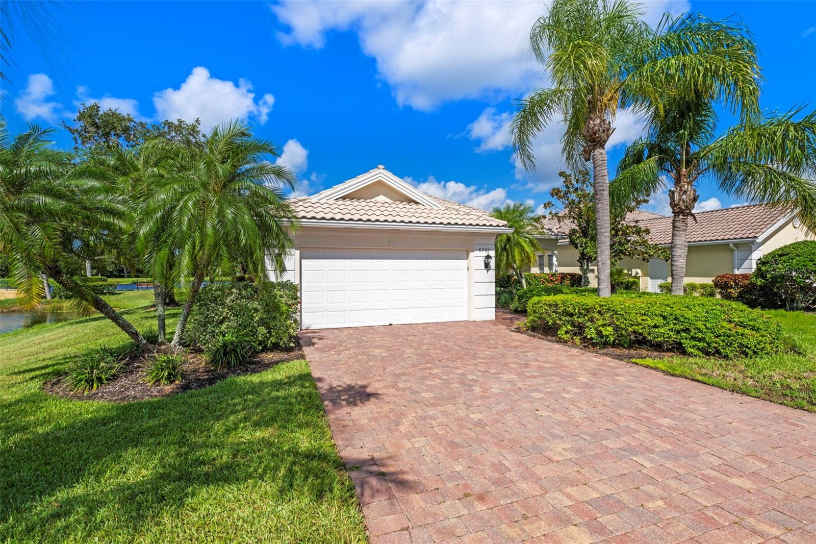 Exceptional Waterfront Carlyle Home on a Cul-de-Sac!
Located in the sought-after community of VillageWalk, this beautifully maintained 4-bedroom Carlyle model offers a spacious open floor plan and sits on a premium waterfront lot with water on two sides. Enjoy peaceful outdoor living with an awning-covered lanai and extra deeded driveway space for added convenience. Interior features include 10- and 12-foot ceilings, neutral ceramic tile flooring throughout the main living areas (2018), crown and detail moldings, motorized blinds in the front of the home, and a cozy fireplace in the living room. The family room boasts a built-in wall unit, perfect for entertainment and storage. The kitchen is designed for both function and style with Corian countertops, a closet pantry, and a newer microwave. The guest bathrooms feature updated quartz countertops, while the primary bathroom includes granite counters, a soaking tub, walk-in shower, vanity table, and generous storage with a walk-in closet plus three additional closets. One of the guest bedrooms includes a built-in setup ideal for a home office. Other recent updates include a brand-new hot water heater, cabinets in garage and an A/C system from 2017. DiVosta built to last with poured concrete reinforced construction. VillageWalk is a guard-gated, resort-style community offering outstanding amenities: clubhouse, restaurant, tiki bar, boutique, salon, 6 Har-Tru tennis courts, pickleball, bocce ball, lap pool, heated lagoon pool, and miles of walking and biking trails. Golf carts welcome! Conveniently located near Siesta Key Beach, dining, shopping, and top medical facilities. Full-time HOA manager on-site. Call today for your private showing.