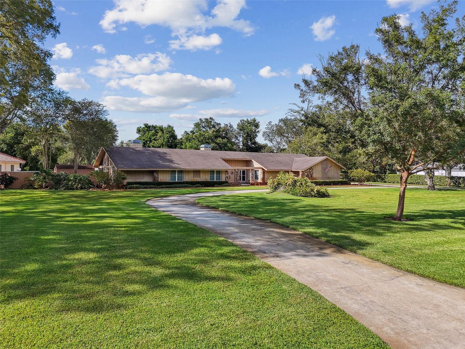 Nestled within the exclusive community of Southoak, this expansive executive-style ranch home sits on a 1.15-acre homesite. The property boasts a large circular driveway and side-entrance garage. As you enter the home through the large double doors you will see the well-appointed great room and kitchen. A significant renovation and addition in 2011 introduced a modernized kitchen and a flexible in-law or office suite featuring a large walk-in closet, full bathroom, beautiful coffered ceiling, tigerwood flooring and separate entrance. The open-concept design seamlessly connects the great room, kitchen, and dining areas, creating an inviting and spacious atmosphere perfect for family living and entertaining. The Large sliding doors off the great room enhance the indoor-outdoor flow. Step outside to discover an expansive outdoor area designed for entertaining with a large, covered patio that extends to a beautiful outdoor pool, a large fully fenced backyard with mature oak trees. There is also a separate fire pit area with seating which provides an additional space for gatherings. All of this creates your own private oasis for relaxation and recreation. Roof 2009, Impact Windows 2015, Sliding Doors 2015, Bamboo and Tigerwood Flooring 2016, Pool and Spa 2016.