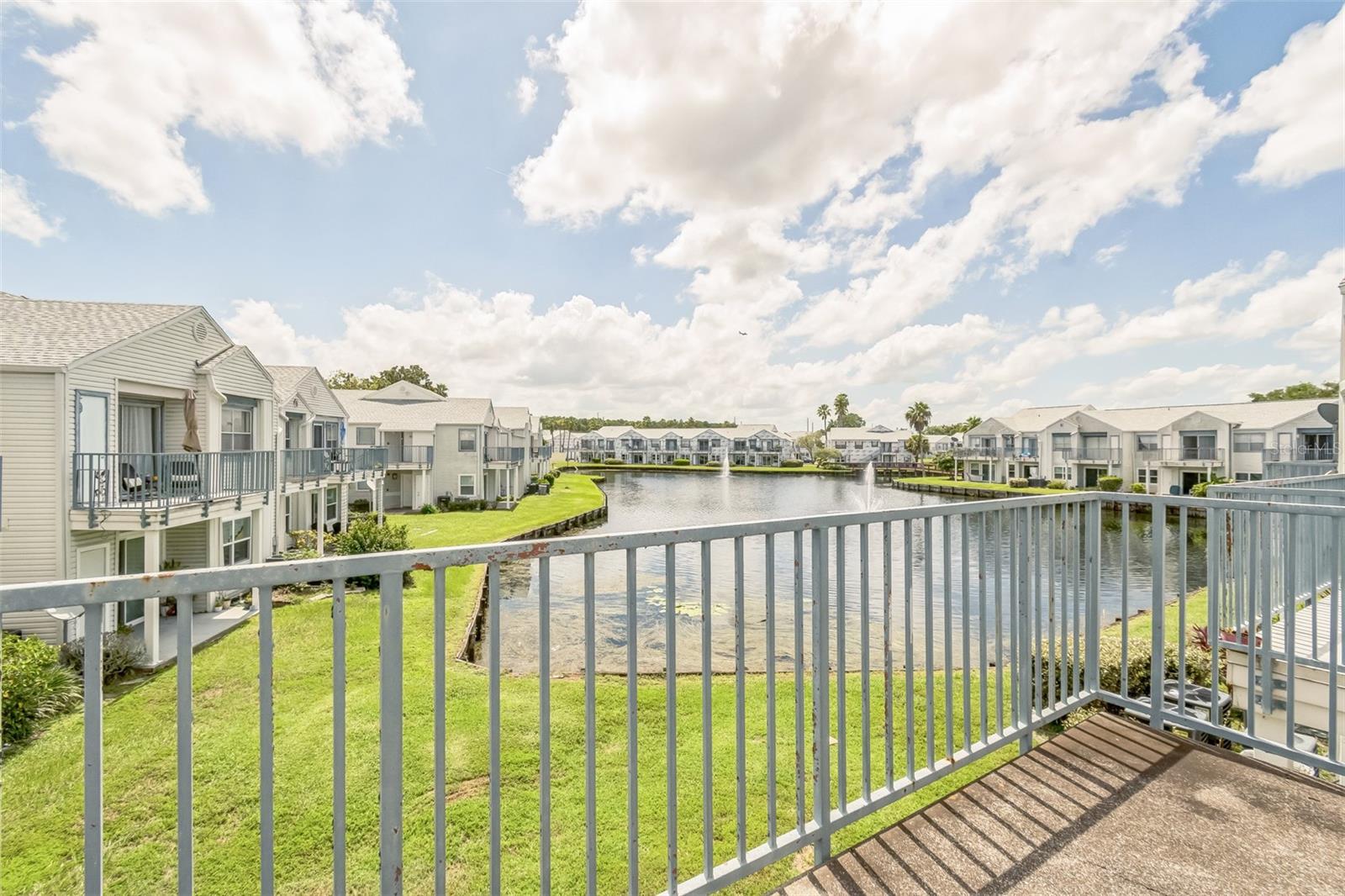 Tucked away in the Dockside Condo community, this second-floor unit offers a functional layout with an open-concept living and dining area, plus a private balcony that overlooks a peaceful water view. The kitchen includes a breakfast bar and connects easily to the main living space, making it perfect for casual meals or entertaining. Vaulted ceilings add a sense of openness, while large windows allow in plenty of natural light. The community itself features gated entry, a pool, and tennis courts, all surrounded by mature trees and serene landscaping. With convenient access to major highways, the airport, and plenty of dining and shopping options, this property offers great potential in a central location.