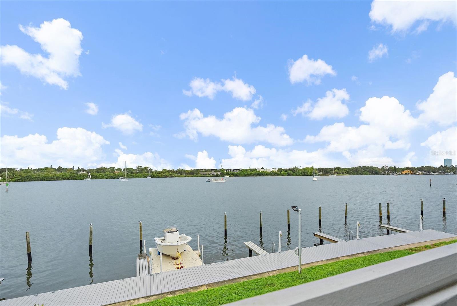 Welcome to Waterside at Coquina Key North, a gated waterfront community where every day feels like a getaway. This 1-bedroom, 1-bath condo offers a light and airy space with French doors opening to your private balcony overlooking Big Bayou — the perfect spot to sip your morning coffee as dolphins play in the water or to wind down in the evening with sunsets that paint the sky in shades of gold and pink. Inside, the home features an updated kitchen with granite countertops, solid wood cabinets, stainless steel appliances, a convenient washer/dryer combo, tile floors throughout, new windows for comfort and efficiency, plus an updated bathroom and generous closet space. Just steps from your door, you’ll find a heated community pool, and beyond that, the neighborhood unfolds with resort-style amenities including multiple pools, tennis courts, a fitness center, clubhouse, kayak storage, dog park, and miles of scenic walking paths along the water. Boat slips are available for rent to accommodate vessels up to 32’, and residents also enjoy access to Waterside South’s private Yacht Club and bar — a great place to gather with neighbors and friends. All this is located only 3 miles from downtown St. Petersburg, with its vibrant dining, shopping, and arts scene, and just a short drive to I-275, the Gulf beaches, and Ft. DeSoto. Whether you’re looking for a full-time residence, a weekend escape, or an investment property, this condo delivers the best of Florida’s waterfront lifestyle.