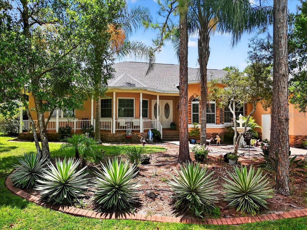 Stunning custom lakefront home on a double lot offering 4 bedrooms, 2.5 bathrooms, plus a bonus office in 2,907 sq ft of living space (totaling 3,436 sq ft under roof) with no HOA and breathtaking water views. This beautifully maintained property features real hardwood floors, vaulted ceilings with custom coffers, a built-in security system, a built-in vacuum system, and abundant natural light throughout. The gourmet kitchen boasts high-end stainless steel appliances, granite countertops, and ample cabinet space, while the living area is anchored by a gorgeous gas fireplace. Enjoy covered front and rear patios with outdoor kitchen hookups, plus a massive wood deck leading to the lake—perfect for entertaining. The oversized three-car garage and enormous 120’ × 28’ driveway provide ample space for RVs, boats, or multiple vehicles, and includes a 30-amp RV hookup. Recent upgrades include a new roof (2025) and new HVAC (2023). Well water with full filtration is in place, with public water available across the street. Located in a quiet, sought-after neighborhood, this home offers the perfect blend of elegance, comfort, and true Florida lakefront living.