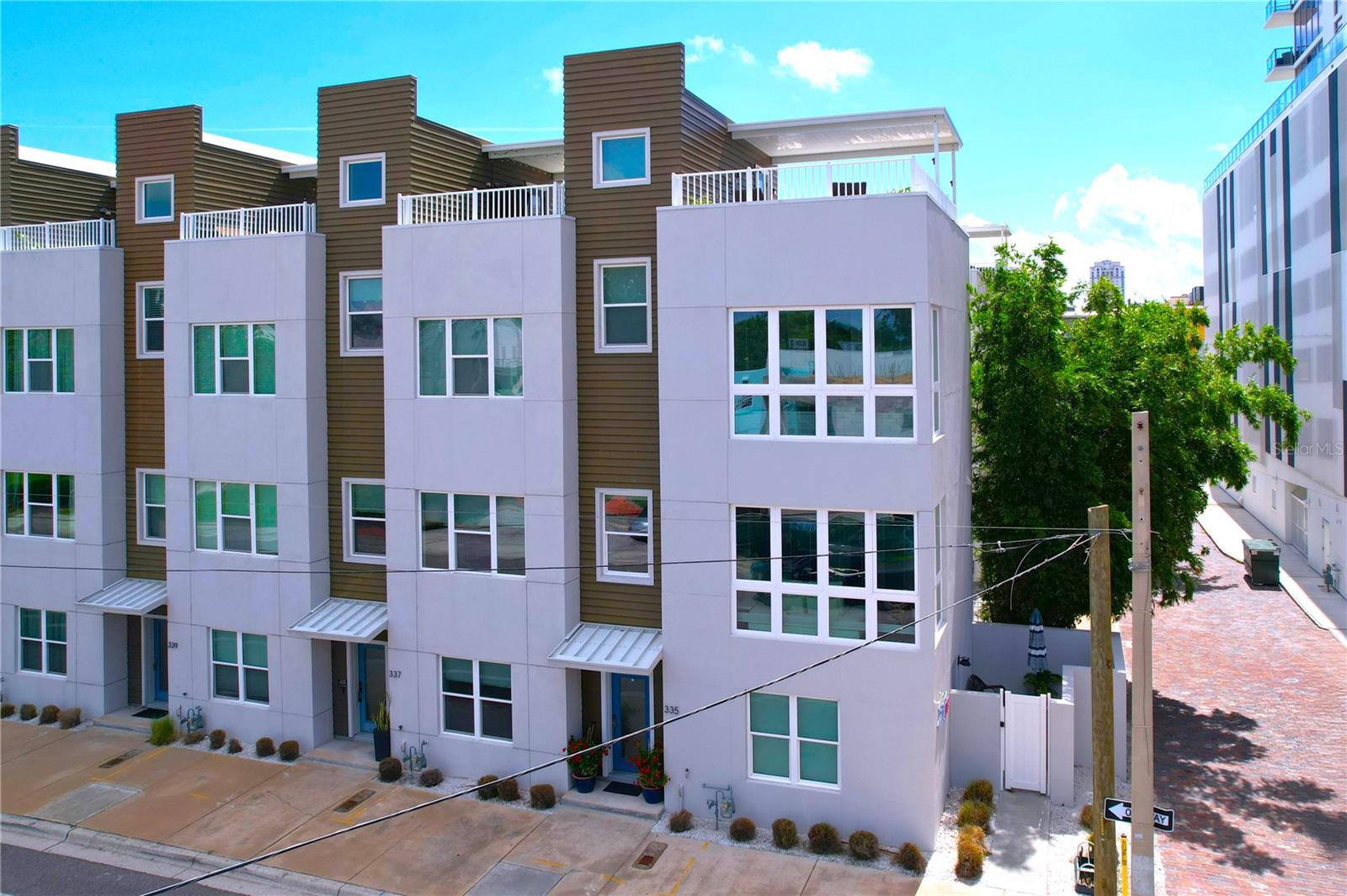 PRICED TO SELL!!! Stunning designer 3 bed 3.5 bath front-corner end unit townhouse in Mirror Lake/Central Arts District. 5-minutes to Central Avenue. Location, location, location to restaurants, shopping, parks and museums and the best St. Pete has to offer. This solid predominantly concrete built townhouse is high quality design/construction and Energy Star certified with hurricane impact windows and doors. On the larger side, it has a spacious and open concept plan with 10-foot ceilings and an abundance of floor to ceiling windows providing an incredible amount of natural daylight. An entertainer's dream is the expansive kitchen/dining/living room complemented with stainless steel appliances (gas range), oversized 10' granite kitchen island seating 4-6, and solid wood cabinetry w/soft close drawers. The primary suite provides floor to ceiling windows, two spacious walk-in closets, and an en-suite bathroom with frameless shower enclosure and dual sink vanity. The other two bedrooms/office have en-suite bathrooms, with an additional half bathroom on the 2nd level. Enjoy indoor-outdoor living is at its best with a very large rooftop covered terrace, indoor wet bar and Trex decking. Take in the spectacular panoramic views of downtown St. Pete. And also, another outdoor space to love: a ground-floor walled-in patio space with locked gate and separate bedroom entrance. Your private oasis. Additional features include laundry closet w/washer & dryer, tankless gas hot water on demand unit, engineered wood floors on two levels, solid surface counters throughout, Levolor window treatments, Ring doorbell, Wi-Fi thermostat and 2-car garage with closet, epoxy flooring and heavy-duty Monkey Bar storage and organization system. Security gated access to the garage. HOA fee includes cable, internet, dog run and more. With an exceptionally competitive price/sqft. take advantage of this rare opportunity now.