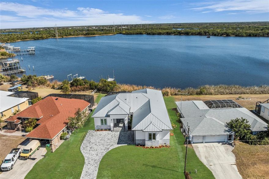 One or more photo(s) has been virtually staged. Featured on Fox4 News! This 4 Bed, 3.5 Bath new construction sailboat-access luxury home in Harbour Heights offers No HOA, No CDD, and effortless Florida living with easy access to I-75. Enjoy Peace River and harbor views with no fixed bridges and direct sailboat access to Charlotte Harbor and the Gulf of Mexico. Just minutes from top local golf courses, downtown Punta Gorda, Fishermen’s Village, restaurants, and waterfront parks, this home combines luxury, convenience, and low-maintenance waterfront living.
With 2,643 sq. ft. of sunlit living space, soaring ceilings, and solid wood soundproof doors, every detail is designed for comfort and sophistication. The chef’s kitchen features premium Bosch appliances, expansive countertops, and a wet bar flowing seamlessly into the living and dining areas.
Step outside to the screened lanai with an outdoor kitchen, perfect for sunset dinners or quiet evenings by the water. The owner’s suite is a resort-inspired retreat with dual walk-in closets, dual-sink vanities, a freestanding soaking tub, Roman shower, and direct lanai access. Additional bedrooms, including a private guest suite, provide comfort and privacy.
Built for both luxury and durability, the home includes impact windows, concrete construction, a metal roof rated for 160+ mph winds, and an oversized EV-ready garage.