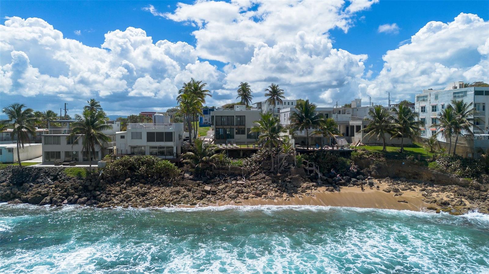 Surf. Relax. Repeat. Welcome to your beachfront oasis, right in the heart of Dorado, Puerto Rico. This oceanfront single-family home offers rare, direct access to one of the Caribbean’s best surf spots—an absolute paradise for surfers and onlookers alike.
The spacious oceanfront deck is perfect for morning coffee with sunrise views or evening cocktails against a breathtaking sunset, offering panoramic tropical island views. The scenery only gets better from the rooftop terrace, where 360-degree ocean views seamlessly blend into the lush tropical surroundings.
Inside, this home is a seamless fusion of modern elegance and tropical charm. With expansive oceanfront views from nearly every room, the open-concept living area is designed for both comfort and style, making it an ideal space for relaxing or entertaining.
Beyond the home's serene setting, its prime location places you close to local favorites like Kikita Beachhouse and Rombo Smokehouse, perfect for enjoying fresh seafood and island flavors. Families will appreciate being just 12 minutes from TASIS and Dorado Academy, two of the area's top private schools. Plus, the world-renowned Dorado Beach Resort is only 15 minutes away.
With strong rental potential and an established short-term rental history, this property is a rare investment opportunity in one of Puerto Rico’s most sought-after coastal markets.
A beachfront home in Dorado is a rare find—offering both laid-back island luxury and high-income potential. Whether you’re looking for a private retreat or a high-performing rental property, this home delivers the best of both worlds.
