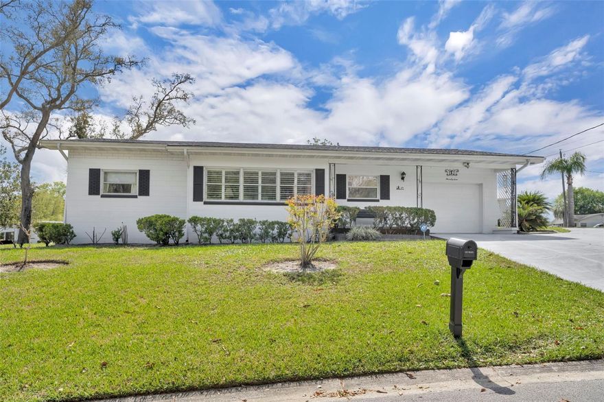 This well-maintained DeBary home makes a great first impression the moment you arrive, offering over 2,000 square feet and sitting on an elevated corner lot across from Lake Anna Marie with a partial lake view! The circular driveway provides plenty of parking and adds to the curb appeal. Large bedrooms, a fenced-in yard, storage shed, 1-car garage, and a bonus room that could easily be a third bedroom give this solid block home more space and flexibility than your typical 2-bedroom, 2-bath. Major updates have already been taken care of, such as a 2022 roof and 2017 HVAC, giving buyers peace of mind. Natural light fills the main living areas, with large windows bringing in glimpes of the lake. Double-pane windows and plantation shutters in the front living space create a clean, finished look, while wood-look ceramic tile flooring ties everything together. The spacious primary suite offers a comfortable retreat with an ensuite bathroom that includes dual sinks. The kitchen layout is functional and has crown molding, ample cabinet space and two lazy Susans. You will also enjoy a lake view from the kitchen window, a small detail that adds to the overall feel of the home. The bonus room is a true highlight, offering bright, flexible space off the main living area with a door for added separation and backyard access, perfect for a third bedroom, office, den, or second living area. The indoor laundry room gives you extra storage and has a door leading straight out to the patio in the backyard. Outside, you have a partially fenced yard with room to spread out, plus a shed for extra storage. Exterior lighting makes the backyard functional in the evening. This home is a true testament to the quality of its construction. Built with solid block and standing strong for many years, it has been very well cared for and offers the kind of durability buyers feel confident in. Located in the heart of DeBary, you are just minutes from the SunRail station, I-4, shopping, and restaurants, making daily life easy whether you are commuting or just running errands. This home has only had two owners, and now it is ready for the next one. If you have been looking for something that is different from the rest, then this is the one! Shown by appointment only.
