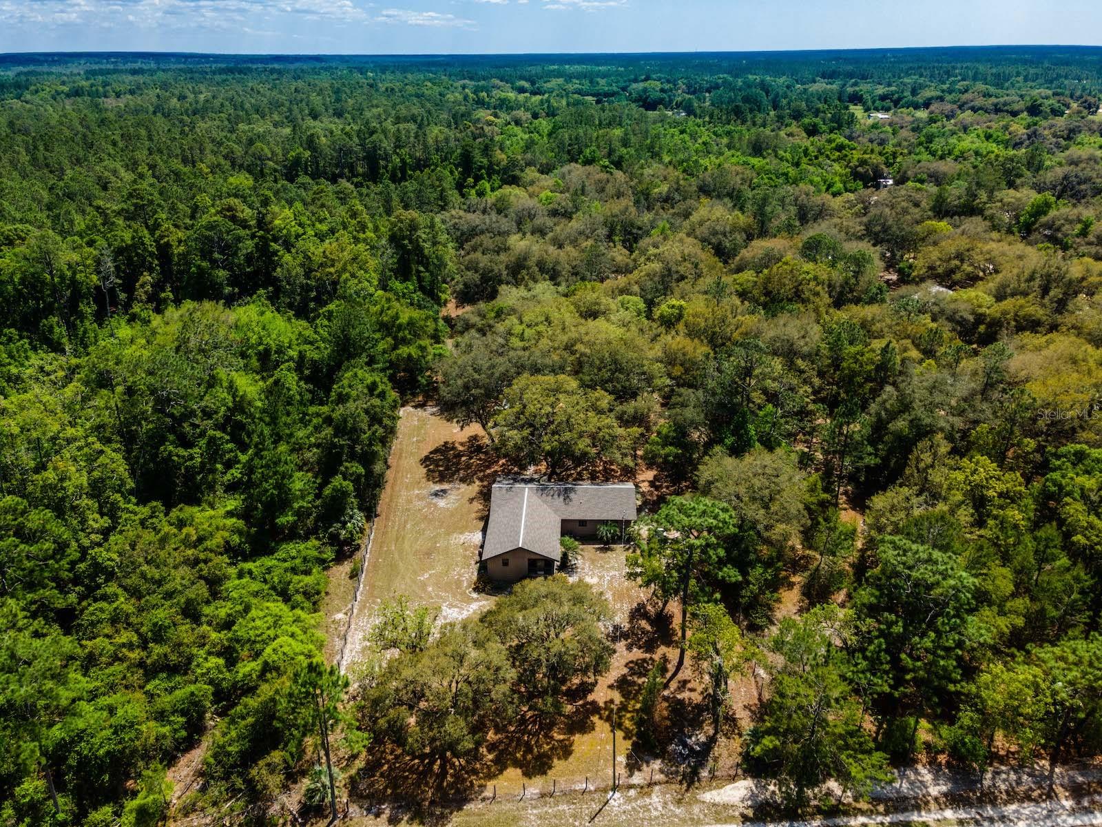 8.29 Acres of fenced, quiet, secluded country living. Don't miss this 4 bedroom, 2 bathroom manufactured home with huge additions and 2365 living square feet. Originally built in 1983 the home has been updated over the years including bathrooms, kitchen, flooring, drywall, new HVAC 2025 and updated roof in 2022. Entering the home, you are greeted by large kitchen with dining area including lots of cabinets and counter space. Living room and dining room combo is 30' x 13' with sliding glass door leading to covered back porch(352 s.f.). Main bedroom is 254 s.f. with bathroom including fiberglass shower and single vanity. Guest bedrooms are nicely sized and guest bathroom with garden tub, tiled floor and surround, and single vanity. Bonus room could be used as additional bedroom, family room or keep it as it's current gym. Outside is a sidewalk leading to 18'x30' workshop with power and water. Located 20 minutes from downtown Fort McCoy with a grocery store, doctor's office, pharmacy, hardware, gas station, pizza, and more. Short drive to Silver Springs which includes Walmart, Lowes, Bealls, Outback and many more of your favorite shopping spots and restaurants. Ocala is only another 15 minutes from Silver Springs with vibrant night life and lots of entertainment options and restaurants. Gainesville(Home of Florida Gators) is only 50 minutes to downtown. If you’re a fisherman, or hunter or simply love hiking, canoeing or kayaking you are in luck! Minutes to Ocklawaha River, Ocala National Forest, and many natural springs(Salt Springs, Silver Glen Springs, Juniper Springs), horseback and walking trails, and off-road vehicle trails await your explorations. One-of-a-kind property and location! Ready for new owners!
