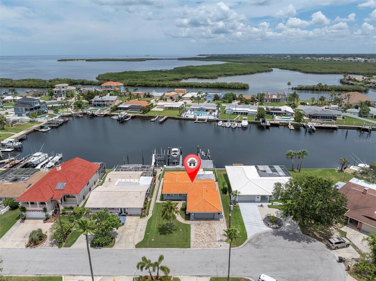 Calling all boating enthusiasts – this is a boater’s dream come true. Located on one of the widest and deepest canals in Flor-A-Mar/Gulf Harbors, this beautifully updated 3-bedroom, 2-bath, 2-car garage pool home offers direct access to the Gulf of Mexico in just minutes. Situated on a quiet cul-de-sac, this home is one of the few properties that can accommodate nearly any size vessel or sailboat with both a 16,000 lb and a 10,000 lb boat lift, as well as a 12x15 floating dock and large deck space. The dock is equipped with water and a new electric system for the lift (2020), fob-controlled operation, and two green underwater lights that create a stunning evening waterfront atmosphere. The backyard is a private retreat, featuring a 2019 saltwater pool with a spillover spa and a brick paver lanai. An outdoor shower adds convenience after a day on the water, and the entire yard is fenced for added privacy. The driveway has been widened and enhanced with pavers, providing additional space and curb appeal. Inside, the home boasts an open floor plan with expansive water views and travertine flooring throughout. The kitchen was refreshed in 2023 with freshly painted cabinets, new quartz countertops, stainless steel appliances, a large island, and a built-in coffee bar. A spacious laundry room is conveniently located off the kitchen. The master bathroom includes a walk-in shower and dual vanities with updated quartz countertops. The cabinets were painted in the master bathroom. The hall bath also received a full refresh in 2023, including painted cabinetry, quartz counters, and a shower update. Additional recent improvements include a new tile roof (2019), HVAC and all new ductwork (2019), tankless gas water heater (2019), whole-house Generac gas generator (2019), and electric hurricane roll shutters (2019) installed on hurricane-rated windows. In 2025, the home received a new front door and all new interior doors. This home is located in an active boating community with an optional membership to the exclusive Gulf Harbors Beach Club and Civic Center. With over 1,900 square feet of living space and every major system updated, this home offers the perfect blend of waterfront luxury and peace of mind. If you’re seeking true deep-water access and a home ready to enjoy from day one, welcome to Gulf Harbors. Schedule a showing today...must see to appreciate!