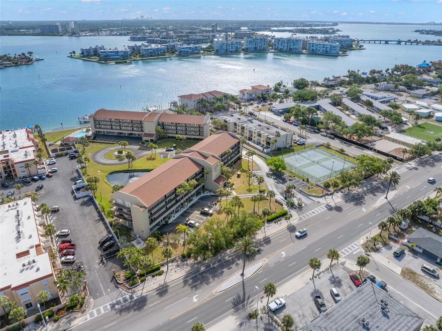 One or more photo(s) has been virtually staged. A must see Gated Community Condo on the Intracoastal Waterway in St Pete Beach.  From the moment you enter into this gorgeous 2 bedroom, 2 bathroom open floor plan with 1070 sqft of living space, hardwood floors throughout and ceilings that are raised 9 feet you realize you have finally made it home.  A Chef's Dream... The updated kitchen offers custom made kraft wood cabinetry with under counter lighting, granite countertops on an endless bar with cooktop, 2 pantries/pull out shelves, glass tile backsplash and JENN-AIR stainless steal appliances.  Just off the living area relax out back on your private 24ft balcony while enjoying you morning coffee or that evening meal while taking in the spectacular view of the community and the breathtaking view of the waterways.  Take a short walk to enjoy your community heated pool or get that daily workout in the workout room/pool house.  Time to retreat... The spacious master bedroom offers an en-suite bathroom with master bath with walk in shower/jetted tub to soak in. Walls tastefully tiled creating spa atmosphere and an oversized walk in closet off bath. The spacious second bedroom offers 1 extremely large closet, plenty of storage space and privacy for guests, with a second full bathroom nearby for convenience. Last but not least walking distance to the blue waters of the Gulf of Mexico, entertainment, shopping, restaurants and a 20-minute drive to Downtown St Pete! You will feel like you are on vacation all year round. Highlights - secured lobby, stairwells with 24/7 security cameras (2025), deeded covered parking with plenty of guest parking, tennis courts, dog/runpark, and potential boat slip ownership.