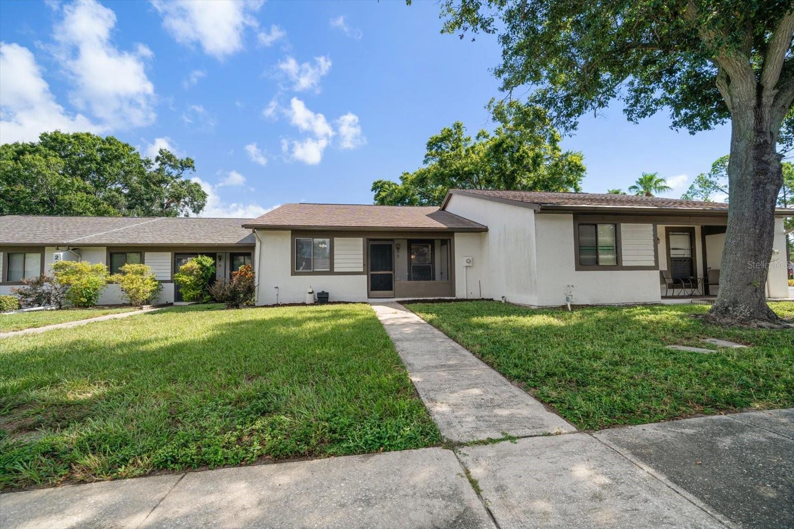 Tucked into the desirable Villas of Beacon Groves community in Palm Harbor, this beautifully updated 2-bedroom, 2-bath villa is the perfect blend of comfort, convenience, and income potential. Move-in ready and filled with natural light, the home features neutral tones and wood-look flooring throughout, creating a warm and welcoming ambiance. The bright white kitchen boasts granite counters, stainless steel appliances, a pantry, and a breakfast bar, seamlessly flowing into the open family room. Sliders lead to a versatile four-season room with indoor laundry and access to a private outdoor patio overlooking greenspace, perfect for relaxing or entertaining. The spacious primary suite offers abundant natural light, a walk-in closet, and an ensuite bath with a walk-in shower. The additional bedroom is equally inviting and shares a beautifully renovated hall bath with a tub/shower combo and a furniture-inspired vanity. With ample storage, a community pool, and a prime location near world-famous beaches, shopping, dining, and airports, this villa is ideal as a full-time residence or investment opportunity. Don’t wait, this one won’t last!
