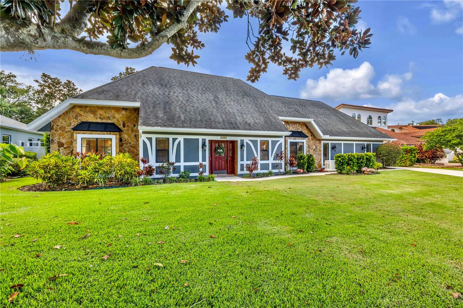 Tudor-Style Estate on Sugar Mill Country Club.
Welcome to this stunning 4 bedroom, 3.5 bath Tudor-style home nestled directly on New Smyrna Beach’s most prestigious golf course, Sugar Mill Country Club. Situated on a quiet cul de sac, this spacious two-story residence combines timeless charm with modern comfort and is designed for both entertaining and everyday living.
Inside, you’ll be greeted by rich Maple wood floors that flow throughout the main living areas. The gourmet chef’s kitchen is the heart of the home, featuring granite counters, copious oak cabinetry, a cooking and eating island, dining nook with wet bar, and plenty of room to gather. The open living area with wood-burning fireplace and Magnificent Maple flooring throughout offers warmth and comfort, while sliding doors lead to a private deck with sweeping golf course views, perfect for heckling your friends on the fairway.
The split bedroom plan provides privacy, with the primary suite boasting a whirlpool tub, generous closet space, and serene views. A huge 26x15 bonus room overlooks the course, ideal for a game room, media retreat, or private office. Additional highlights include tons of storage, an interior laundry, Generac Whole House Generator, and a 2 car plus golf cart garage.
Set on a large lot with room for a custom pool and summer kitchen, this property offers endless potential to create your own private retreat. Whether hosting family, entertaining friends, or simply enjoying quiet evenings on the deck, this home captures the perfect blend of elegance and Florida lifestyle living. Be sure to check out our video walkthrough of this beautiful home.