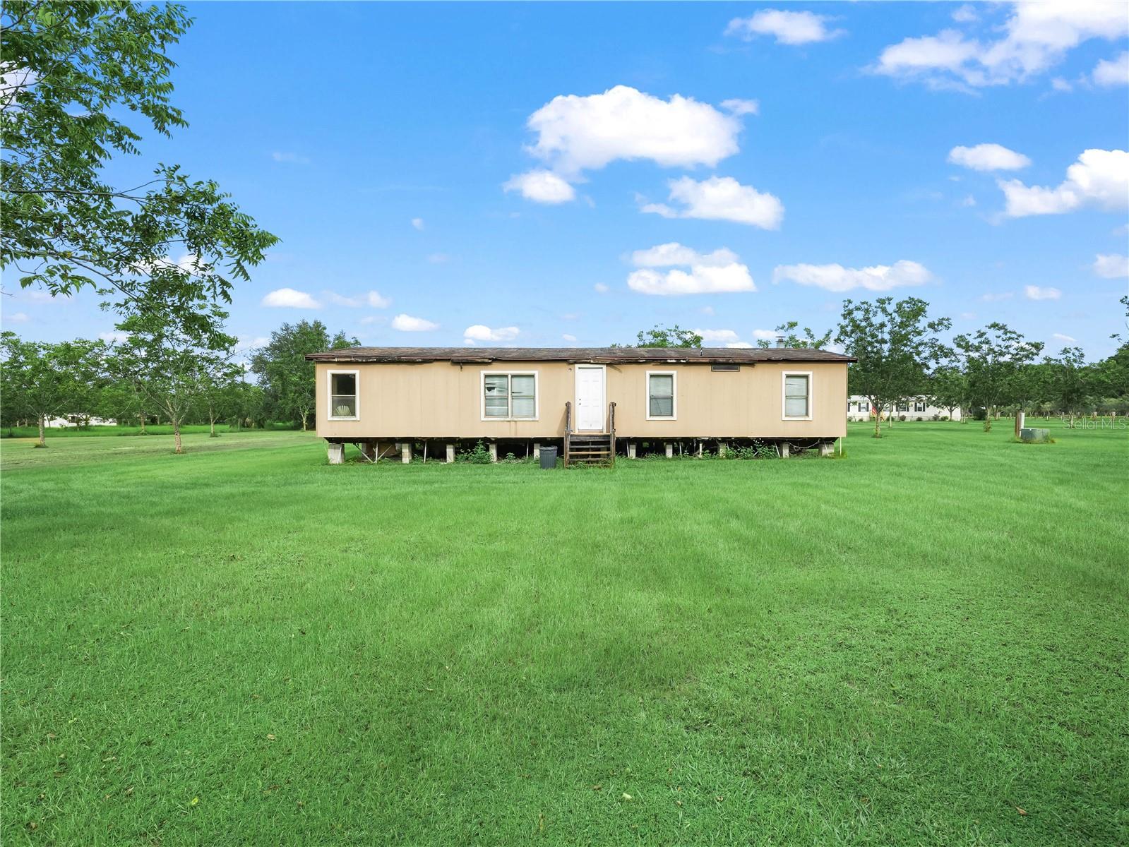 Peaceful Country Living on 2.44 Acres
Discover the charm of rural Florida living on this high and dry 2.44-acre property nestled in the heart of Lithia. Lined with rows of mature pecan trees, this expansive lot offers a serene setting perfect for those seeking space, privacy, and a connection to nature.
The property features a 1986 double-wide mobile home with 1,512 square feet of living space. While the home needs work, it presents a great opportunity for a full remodel or replacement to create your ideal country retreat.
With 164 feet of frontage and 841 feet of depth, there’s plenty of room for farm animals, gardening, or building your dream home. Zoned for agricultural use, this property currently benefits from a greenbelt exemption on approximately 2.19 acres, helping reduce property taxes.
Located in a quiet, rural area yet still within reach of modern conveniences, this is the perfect spot for those looking to embrace a peaceful, country lifestyle.