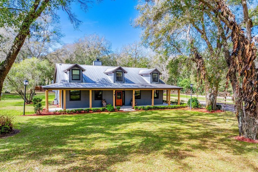 Almost SEVEN PRIVATE ACRES | A CUSTOM BUILT HOME | And a property designed for the way you actually want to live! Welcome to this rare opportunity in charming Eustis, with scenic Lake Eldorado as the picturesque backdrop to this quiet community. Set on 6.91 high and dry acres and ZONED AGRICULTURAL, this beautiful 3 bedroom, 2.5 bath home sits perfectly centered on the property, surrounded by mature trees, fenced pastures with run-ins for cows, and wide-open skies. Bring your animals, your RV, your hobbies, and your vision – there is room for all of it here. And best of all… NO HOA! Major updates and features include EXTERIOR PAINT (2021), METAL ROOF, TANKLESS WATER HEATER, maintained well and septic systems, an underground 150-gallon Amerigas propane tank, gas range, gas dryer, gas hot water heater, 2 A/C UNITS (4-ton for the main living areas and 2-ton dedicated to the primary suite), 11-zone irrigation system with three clocks, and a commercial-grade electric ENTRY GATE with remotes and keypad access. The 32x40 pole barn with a 16’ lean-to offers incredible flexibility – complete with a 16x16 concrete-floored workshop or tack room equipped with its own bathroom, plus an additional 16x16 concrete slab under open air. A 50-amp RV HOOKUP is positioned under the pole barn for easy access, and an 8x16 tractor barn sits in the back pasture. The lean-to can even be converted into horse stalls, making this a true working property with lifestyle appeal! Inside, the home balances warmth and functionality with an OPEN CONCEPT main living area, vaulted ceilings, and a charming stacked stone WOOD BURNING FIREPLACE with an oversized hearth. Natural light pours into every corner, creating inviting, airy spaces perfect for everyday living or entertaining. The well-appointed kitchen offers gas cooking, thoughtful storage, and seamless flow into the dining and living areas. The spacious PRIMARY SUITE is a retreat of its own, featuring French doors to the covered porch and TWO WALK-IN CLOSETS – one in the bedroom, and one in your private en-suite bath. MULTIPLE OUTDOOR SPACES – including a built-in FIRE PIT and screened lanai – extend your entertaining space and invite you to enjoy Florida living year-round. And then there is the true standout feature – an actual reinforced safe room. Built with 4-inch poured concrete walls and ceiling, this secure space doubles as a closet and features a must see bank-style door hidden behind a pocket door. It locks from the inside, opens inward, includes a small window, remains under A/C, and has a dedicated fresh-air vent for added safety and peace of mind. Beautiful, functional, and full of character, this property offers the rare combination of acreage, agricultural zoning, modern comforts, and thoughtful upgrades – all in a quiet, well-kept area just minutes from shopping, dining, schools, nearby lakes, and outdoor recreation. Privacy. Freedom. Versatility. Space to breathe. If you have been waiting for a property that truly has it all – this is the one. Call today to schedule a tour and fall in love with your new HOME SWEET HOME! **Seller may consider buyer concessions if made in an offer**