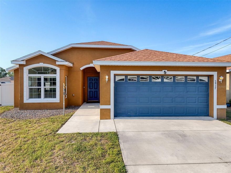 WELCOME to this 2018 build — where Home Meets the HEART OF DOWNTOWN NPR! Tucked into one of New Port Richey's beloved GOLF CART DISTRICTS, this larger fenced corner lot places you just minutes from all the MAGIC OF DOWNTOWN LIFE — think live music in Sims Park, waterfront dining along the Cotee River, a visit to your local YMCA, and the historic elegance of the Hacienda Hotel, all just a short ride from your front door. AS YOU STEP INSIDE this thoughtfully designed 3/2/2, you're welcomed by a warm, inviting foyer featuring an eye-catching designer light fixture, soft gray walls, elevated ceilings, and planter shelves that immediately set the tone for this stylish, comfortable home. The bright and cheerful eat-in kitchen is perfect for entertaining, offering panoramic front yard views, modern black cabinetry with brushed nickel hardware, a stainless steel appliance package including a double-door fridge with ice maker, built-in pantry, secondary utility closet, designer downlighting, and a large breakfast bar with a generous seating area — all flowing seamlessly into the heart of the home. This home hits all the right notes — comfort, character, and convenience. The generous main living area features vaulted ceilings, abundant natural light, and French doors that open to the screened patio and fenced rear yard. A private split-bedroom floor plan enhances the home’s sense of space and function. The spacious primary suite sits up front with soft gray walls, high ceilings, neutral tone flooring, dual sunlit windows, and a generous walk-in closet with HVAC venting. The en-suite bathroom offers a black vanity base, semi-private water closet, designer tile shower with glass enclosure, and an oversized linen or secondary closet — all complemented by natural light through a frosted privacy-glass window. Two additional bedrooms are located at the rear of the home, each filled with natural light and featuring plush, deep neutral-toned carpeting. One bedroom includes a custom wood-trimmed accent wall, adding a unique and cozy touch, while the other offers a bit more space — perfect for a home office, den, or hobby room. These rooms share a full bathroom with a black base vanity and tub/shower combo, creating a welcoming and practical space for guests or family. Step through the french doors to your screened-in patio — the perfect place to relax and enjoy the fully fenced backyard or outdoor firepit. The spacious two-car garage is equipped with built-in cabinets, attic access, and a washer/dryer. — ready to handle all of life’s tasks and storage needs. This home comes with a few extra bells and whistles, NEW Carrier HVAC 2025, Ring doorbell camera, Ring driveway spotlight camera, and 3 ADT cameras that may be used with an ADT subscription. For additional piece of mind, this property does not currently require flood insurance and has hurricane shutters which will help to qualify for insurance discounts. This home feels new, it feels loved, and above all — it feels like home. Just moments from Gulf beaches, Gulf High School, and all the energy of downtown New Port Richey, this location is lifestyle-rich. The current owners enjoy daily golf cart rides to dinner, festivals, and morning coffee — and soon, so can you. Come fall in love with 5917 High Street. It’s more than a home — it’s a lifestyle. Schedule your private tour today before this one gets away!
