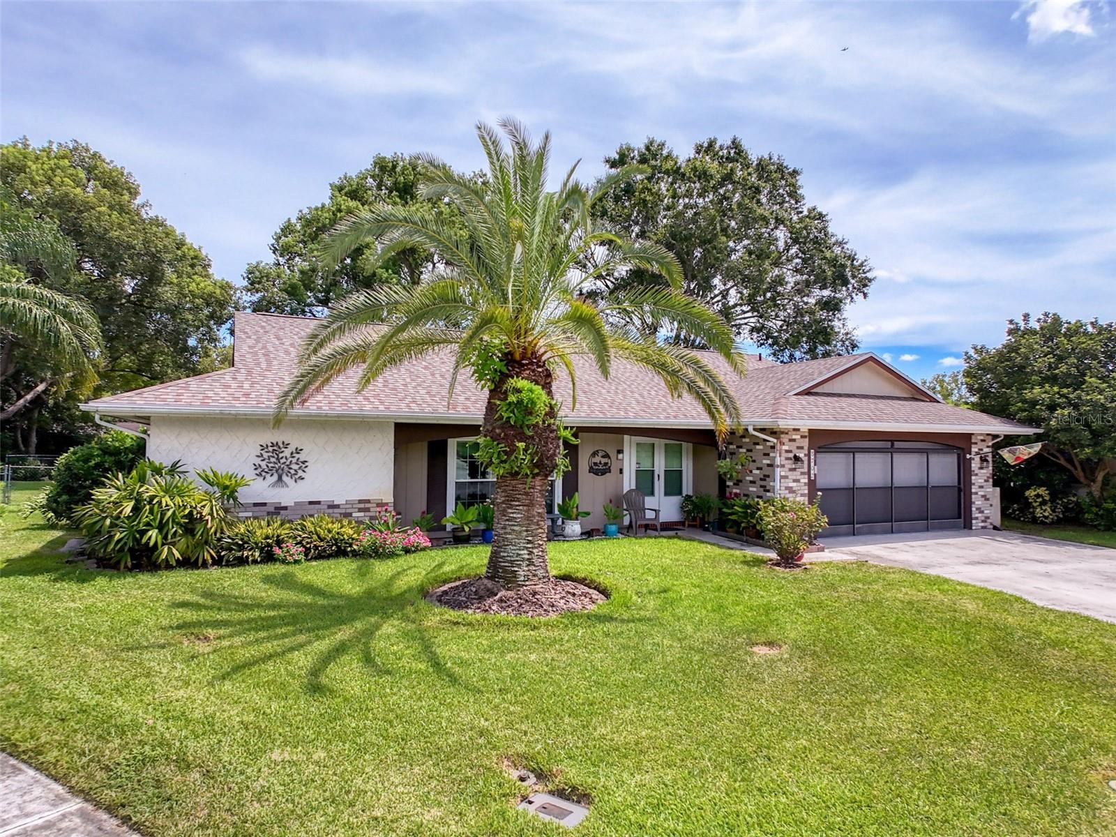 Welcome to your lush sanctuary located at 8702 Lincolnshire Dr in Beacon Woods, Hudson FL. This roomy 2-bed, 2-bath, 2-car garage home has been meticulously maintained by the current owner. As you will see when you drive up the home, the landscaping is impeccable with no expense spared. This home has had major improvements done by the owner in addition to the landscaping. Windows were replaced with impact windows in 2016 along with the front door, A/C change out in 2017. A screened patio was added in 2018, and the hurricane rated garage door and opener were installed in 2020. Finally, the roof was replaced just last year. As you enter the home to the left is an L-shaped living/dining room with access to the primary bedroom at the rear left and access to the kitchen to the right. The end of the dining room gives way to the large bonus room that provides access to the screened lanai. Off the kitchen to the right, there is a nice size family room that has a hallway that leads to the 2nd bedroom and guest bathroom. The floor covering is a combination of wood laminate, living, family and both bedrooms and tiled in all the right areas. The back yard is fully fenced and very spacious with plenty of room to roam. This is a must-see home and should not last that long. You won't be disappointed.